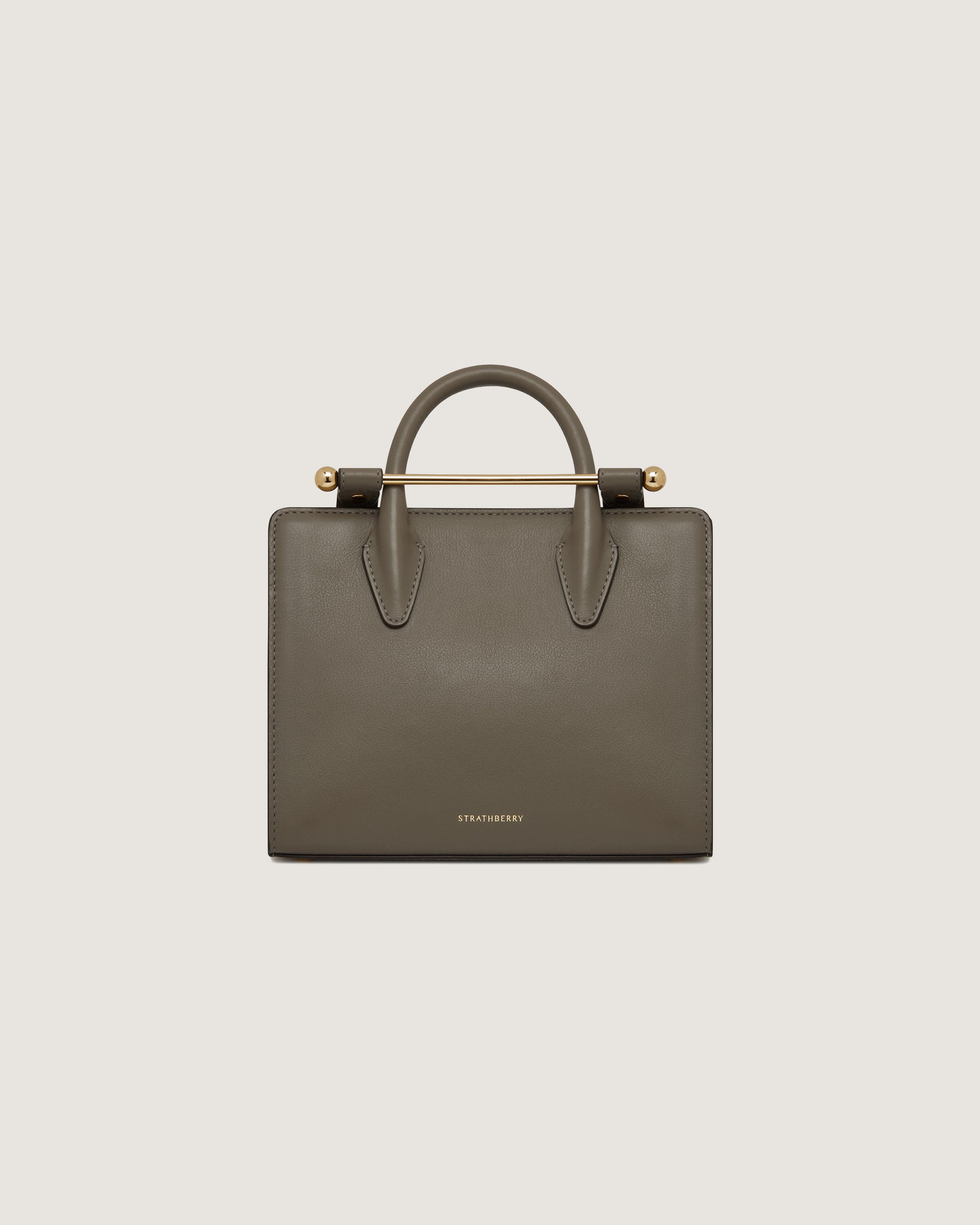 A grey handbag with a gold handle