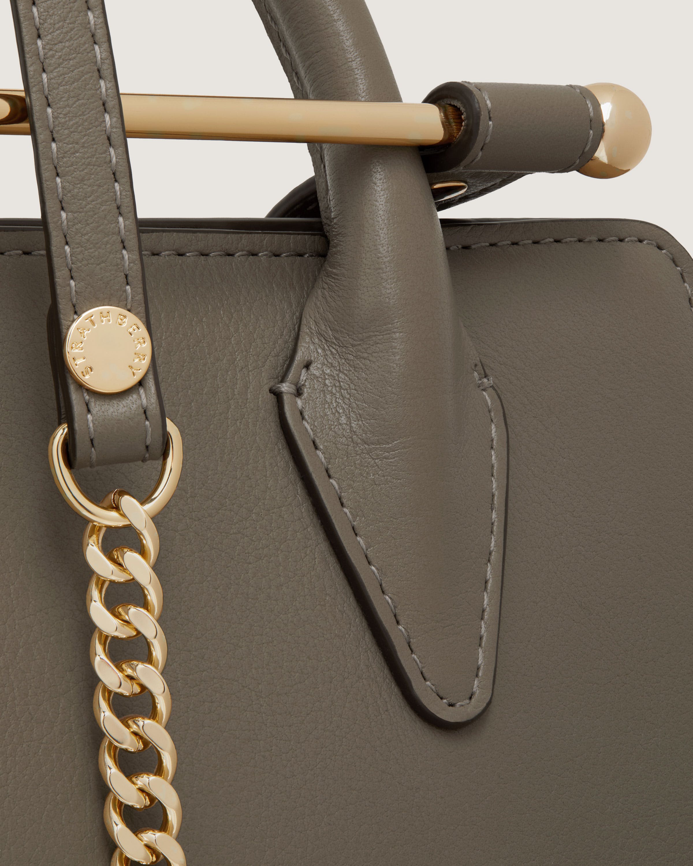 A close up of a handbag with a chain on the handle