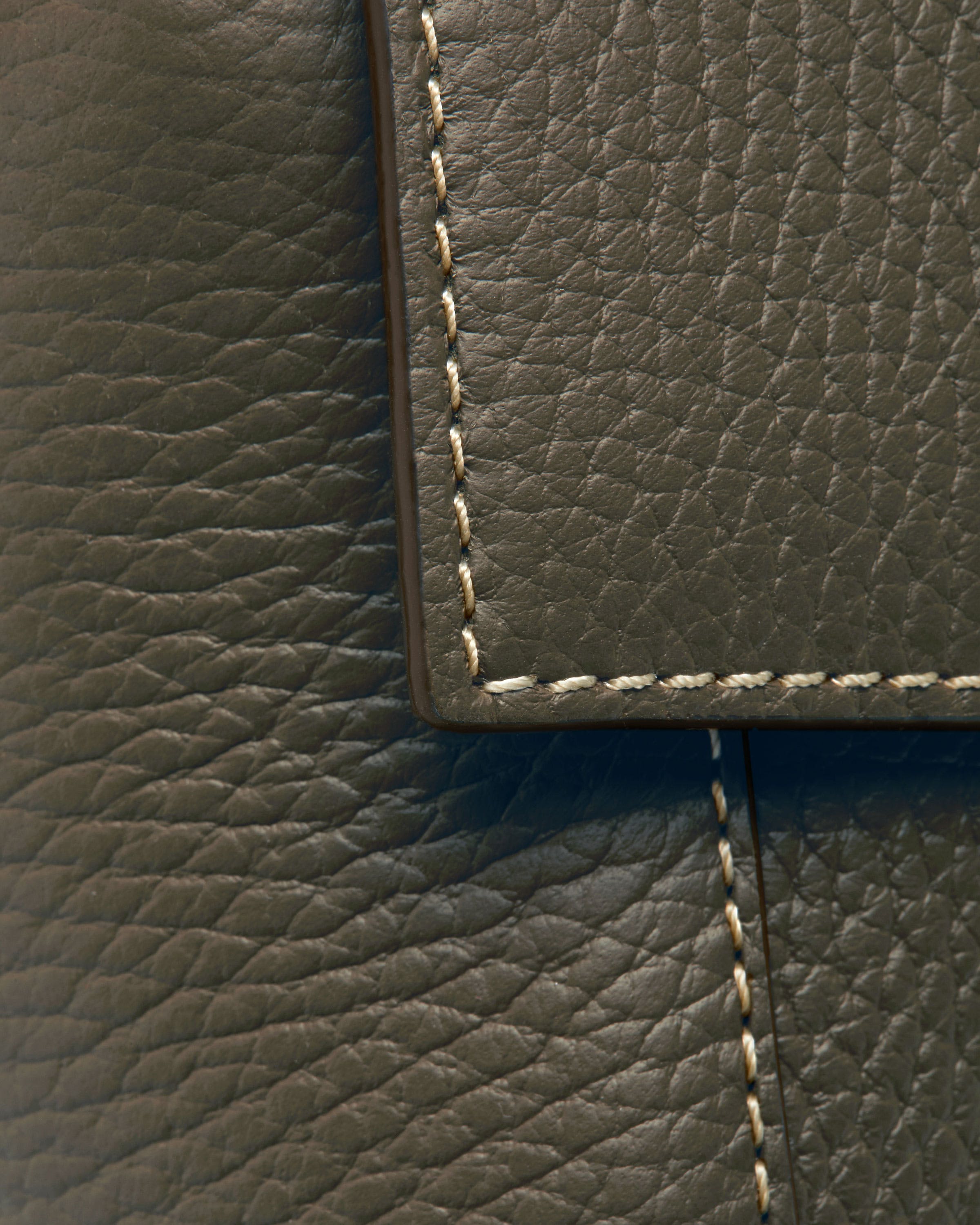 A close up of a cell phone on a leather surface