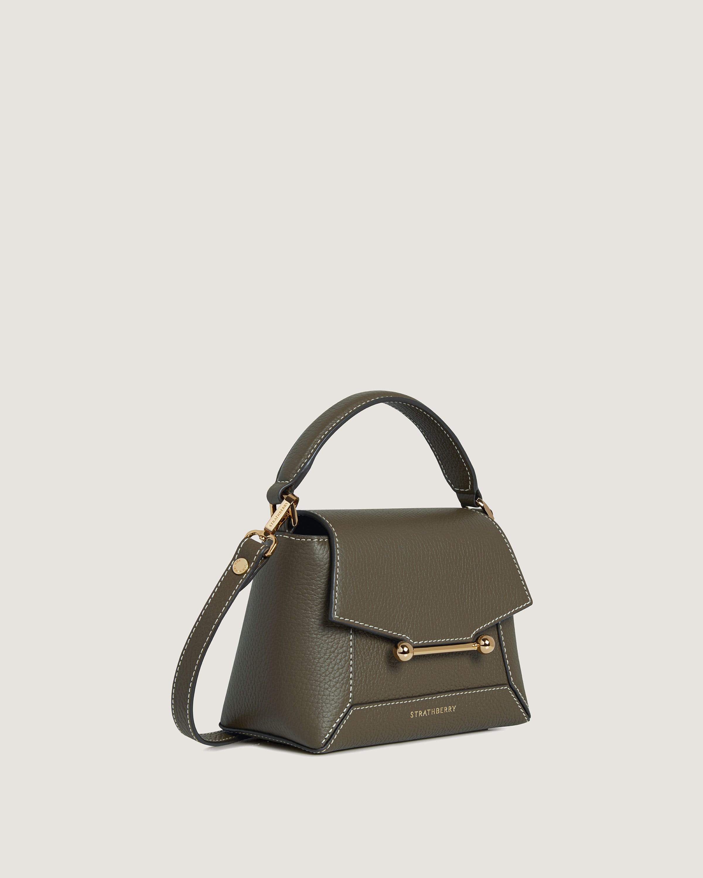 A small grey handbag with a gold handle