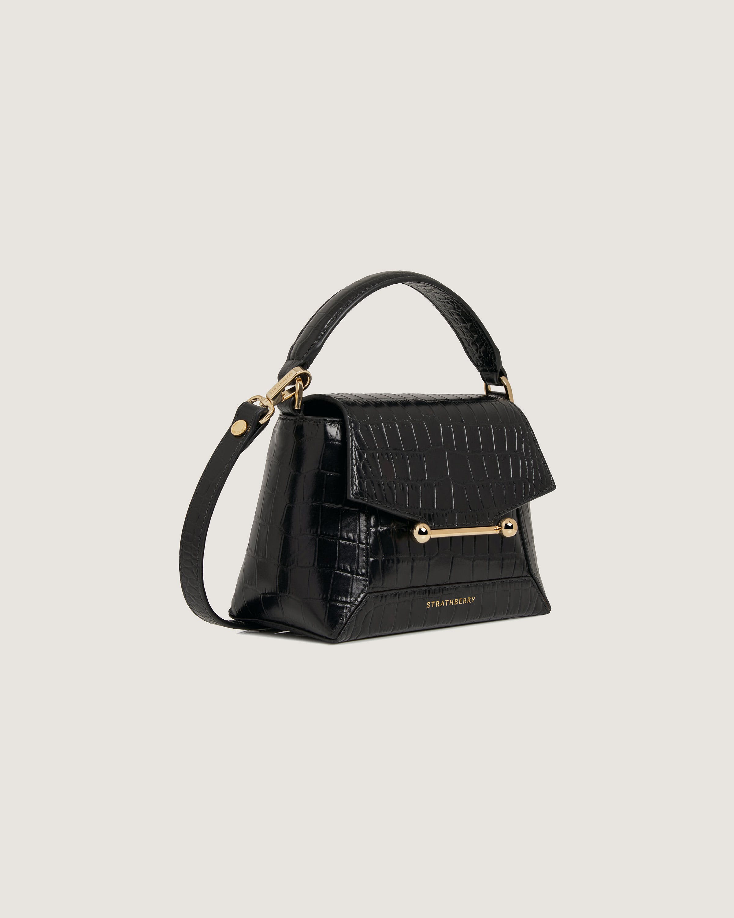 A black handbag with a gold handle