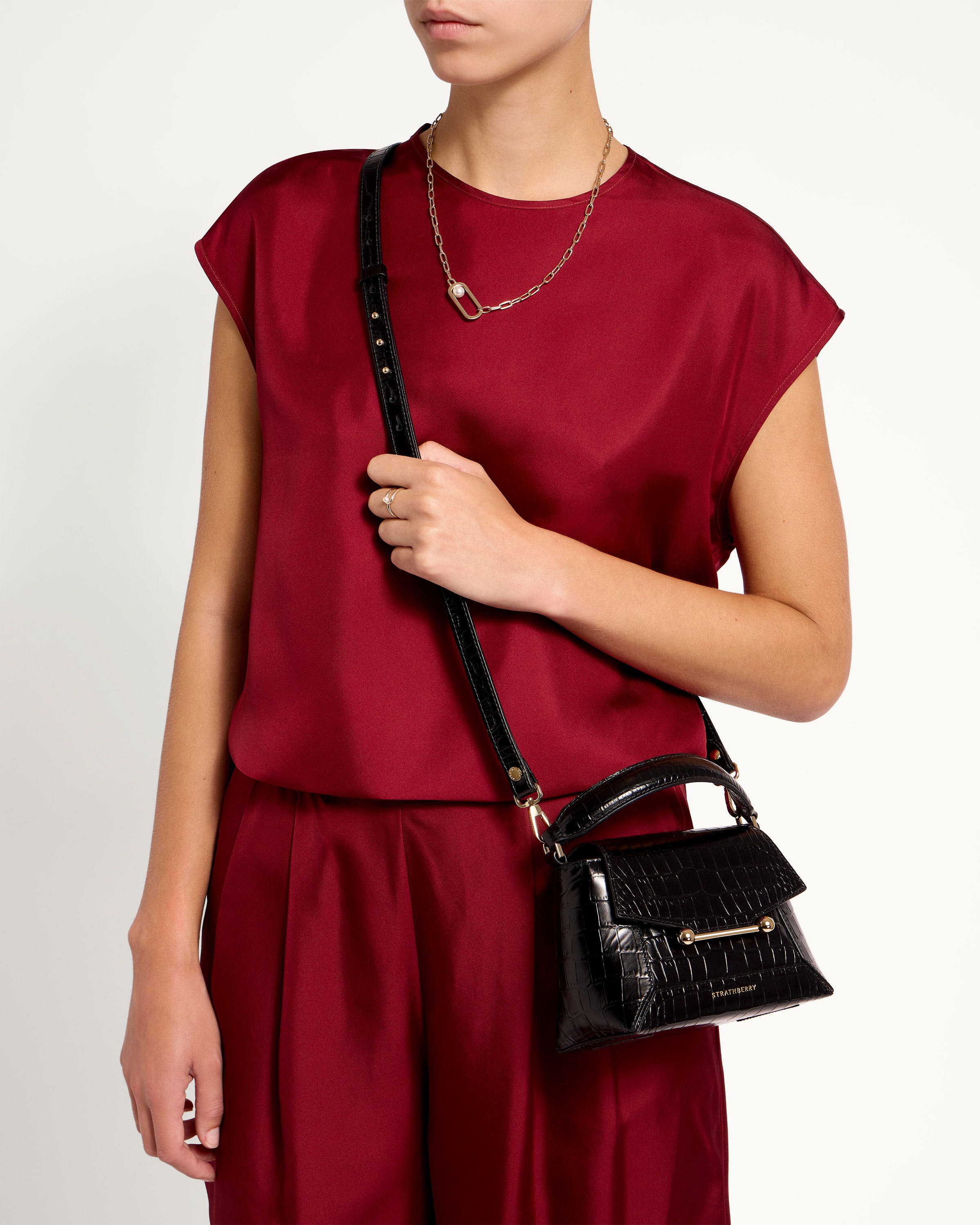 A woman in a red top holding a black purse