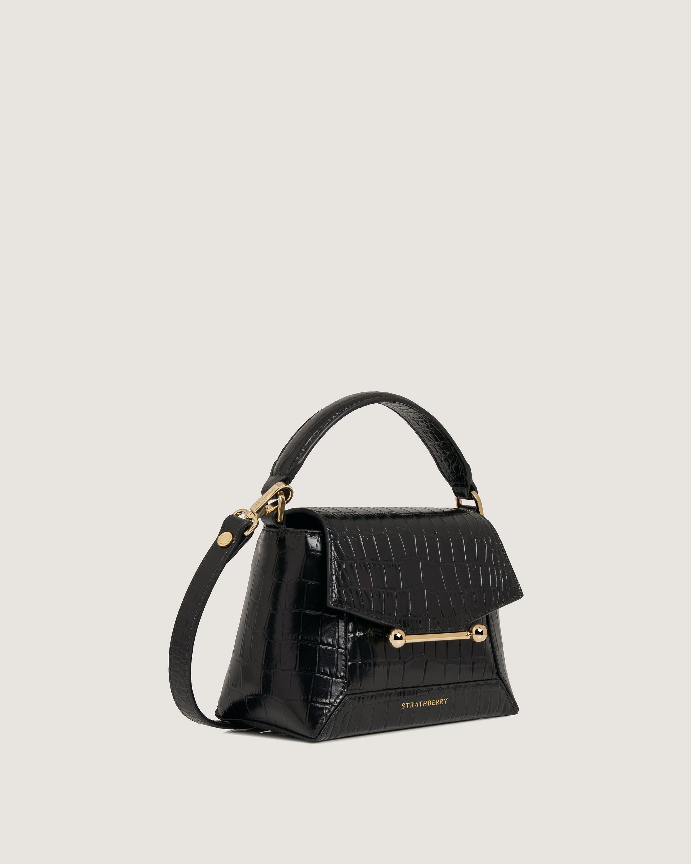 A black handbag with a gold handle