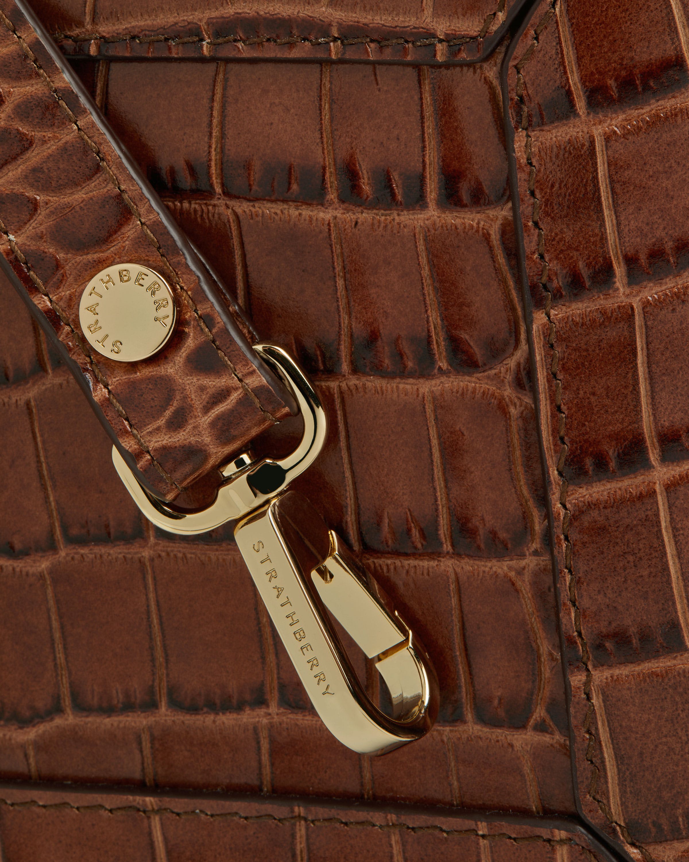 A close up of a brown alligator skin purse