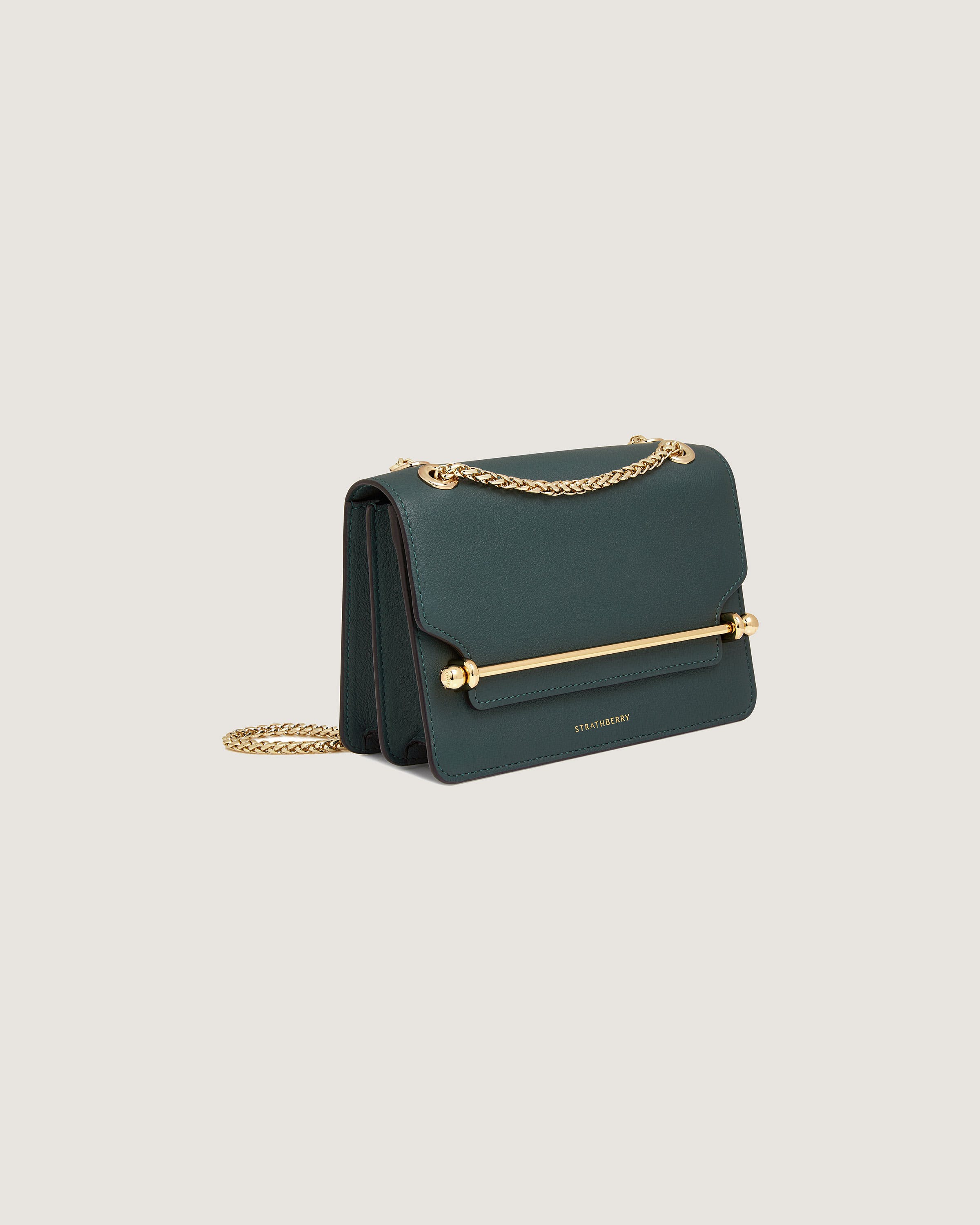 A green cross body bag with a gold chain