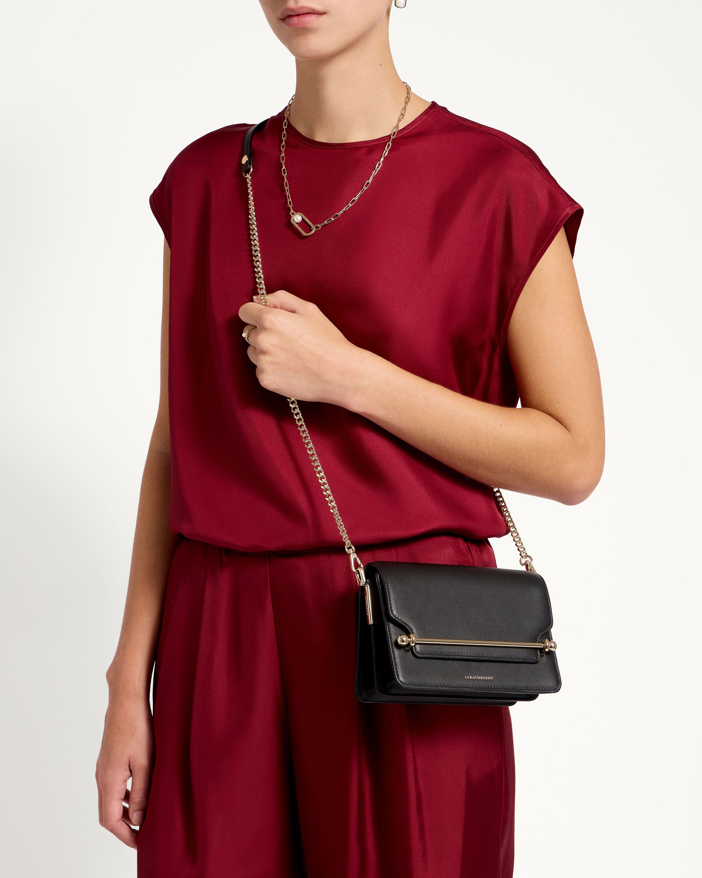 A woman in a red top holding a black purse