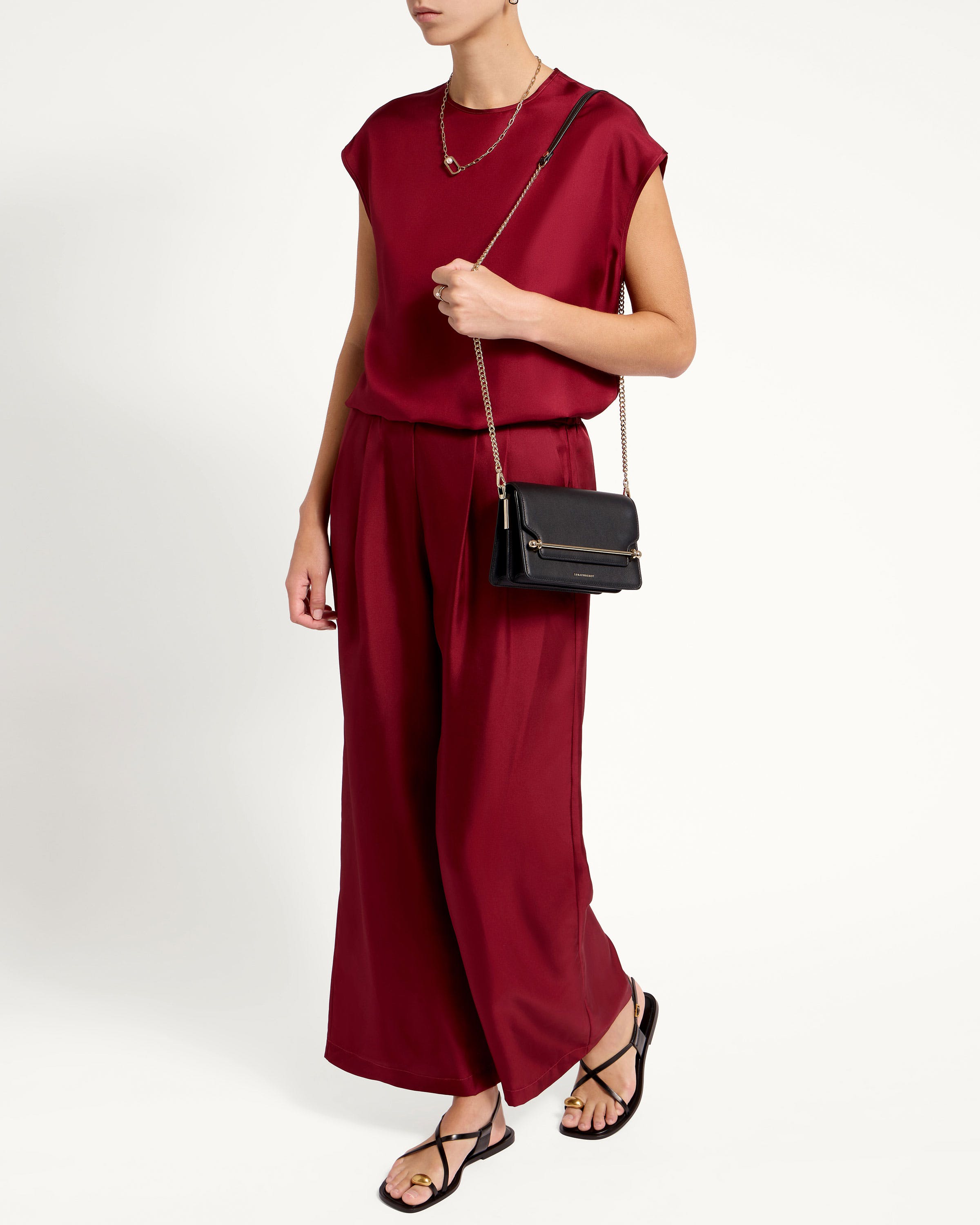 A woman in a red jumpsuit holding a black purse