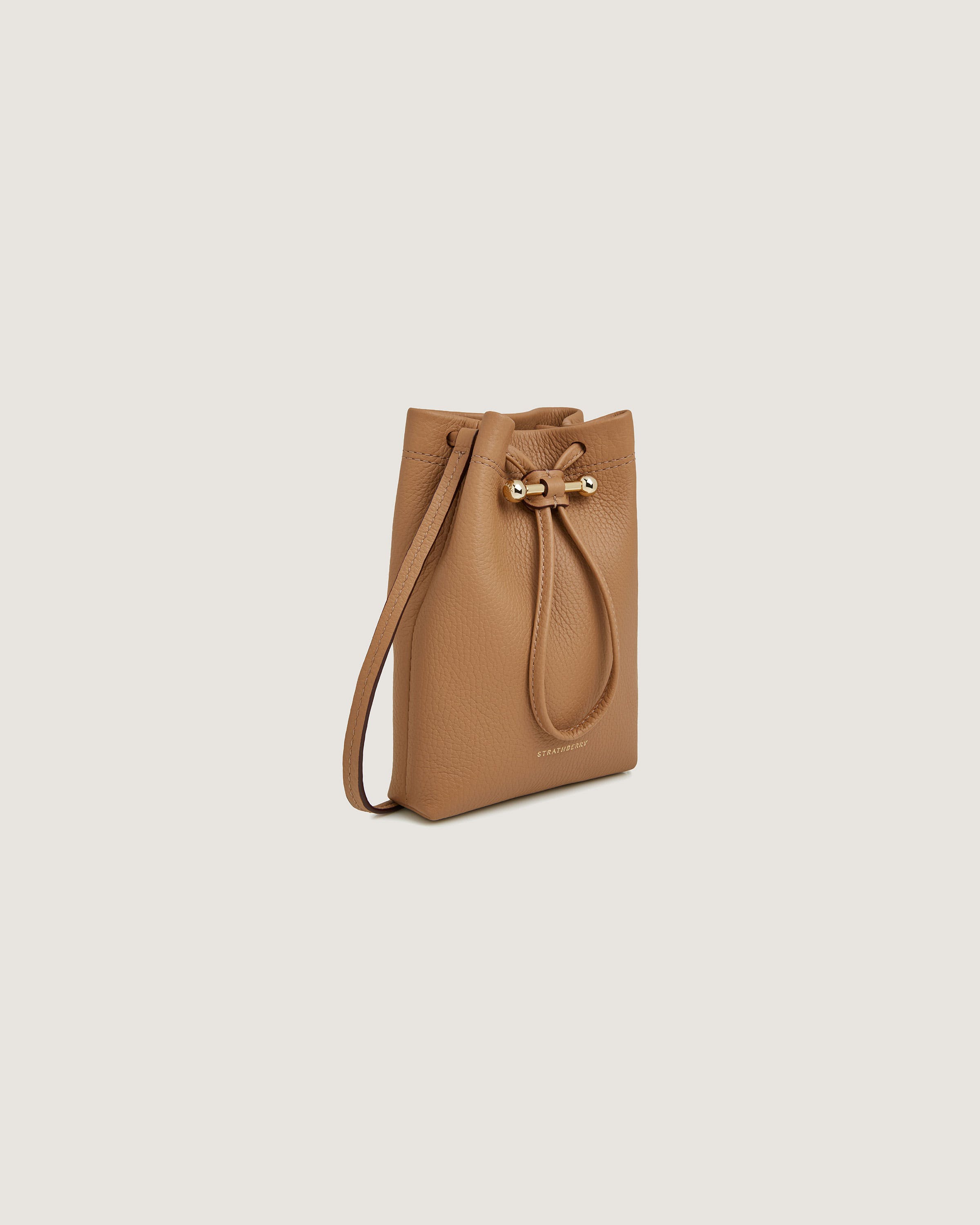 A tan leather bucket bag with a bow on the front