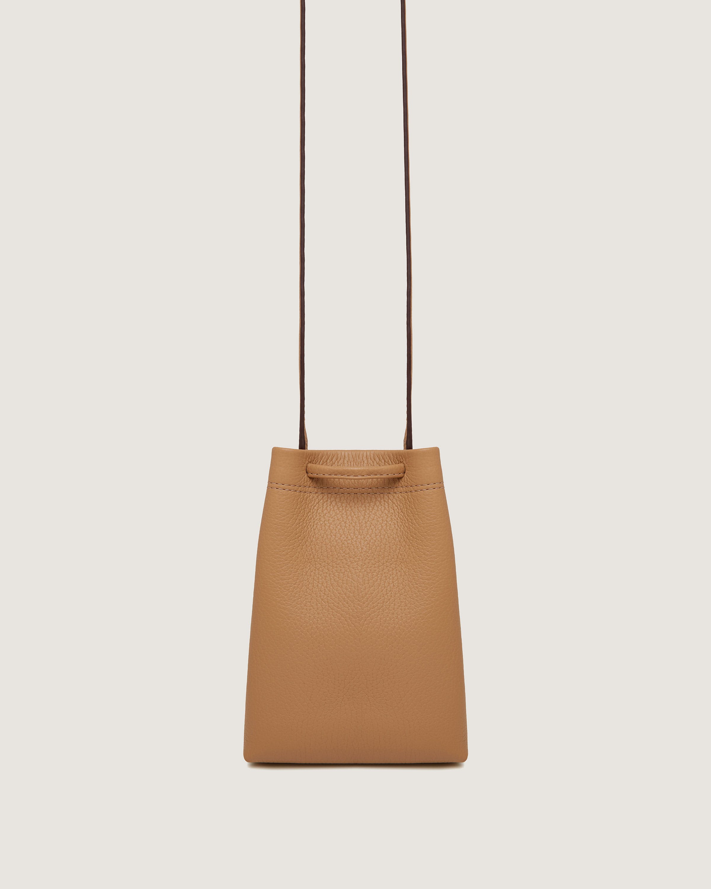 A tan handbag hanging from a brown cord