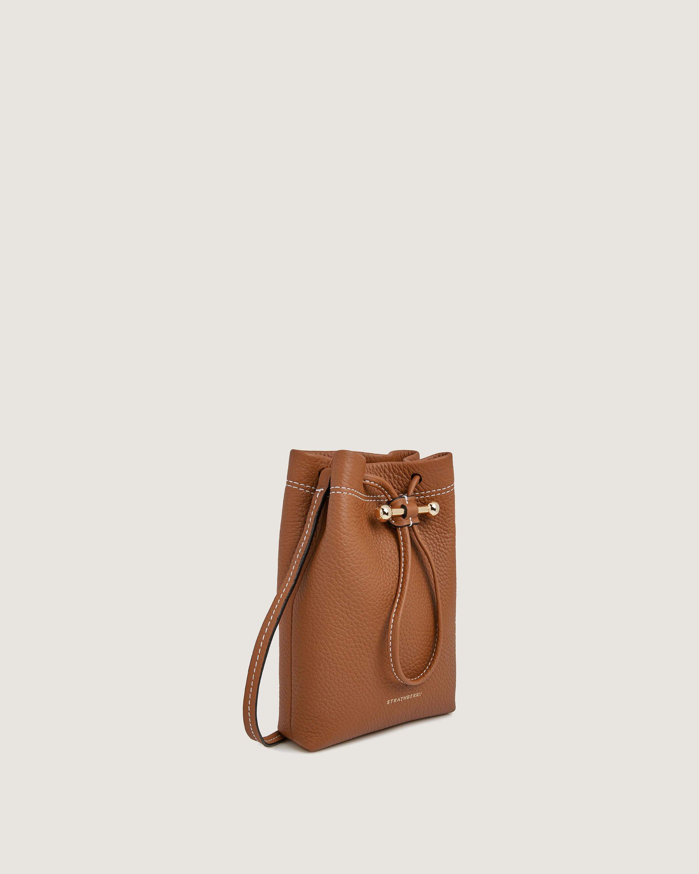 A brown leather bucket bag on a white background