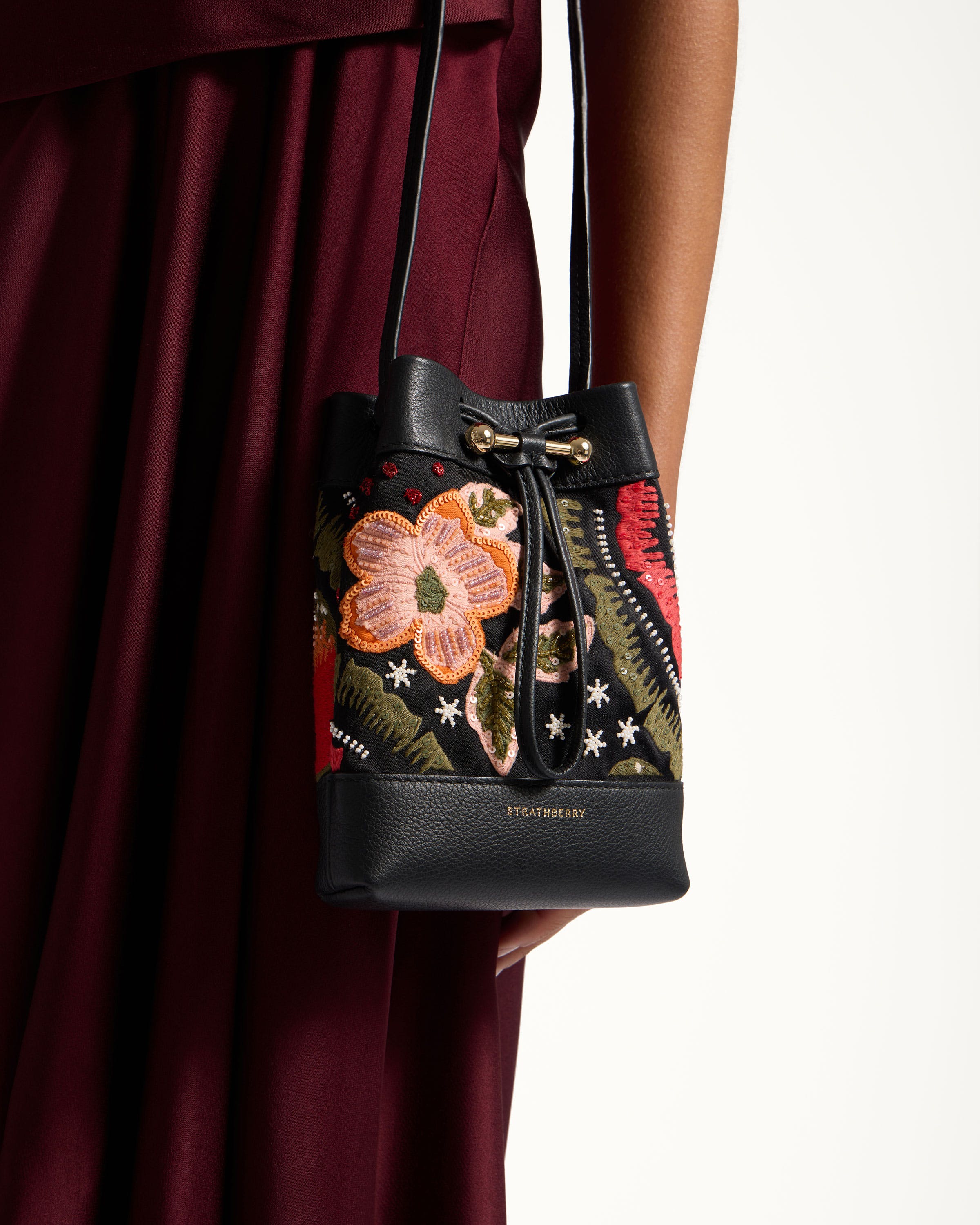 A woman holding a black purse with a flower on it