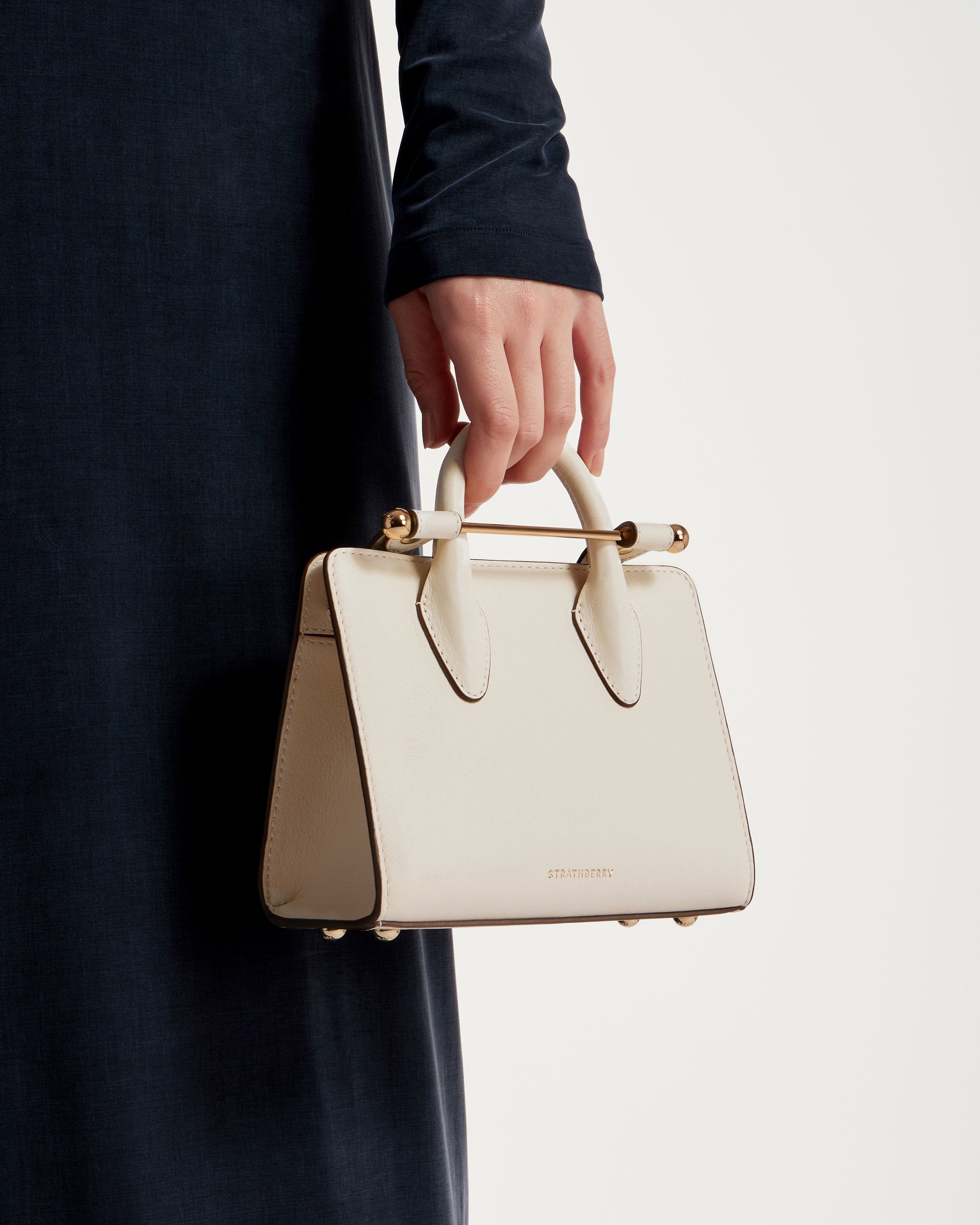 A person holding a white purse in their hand