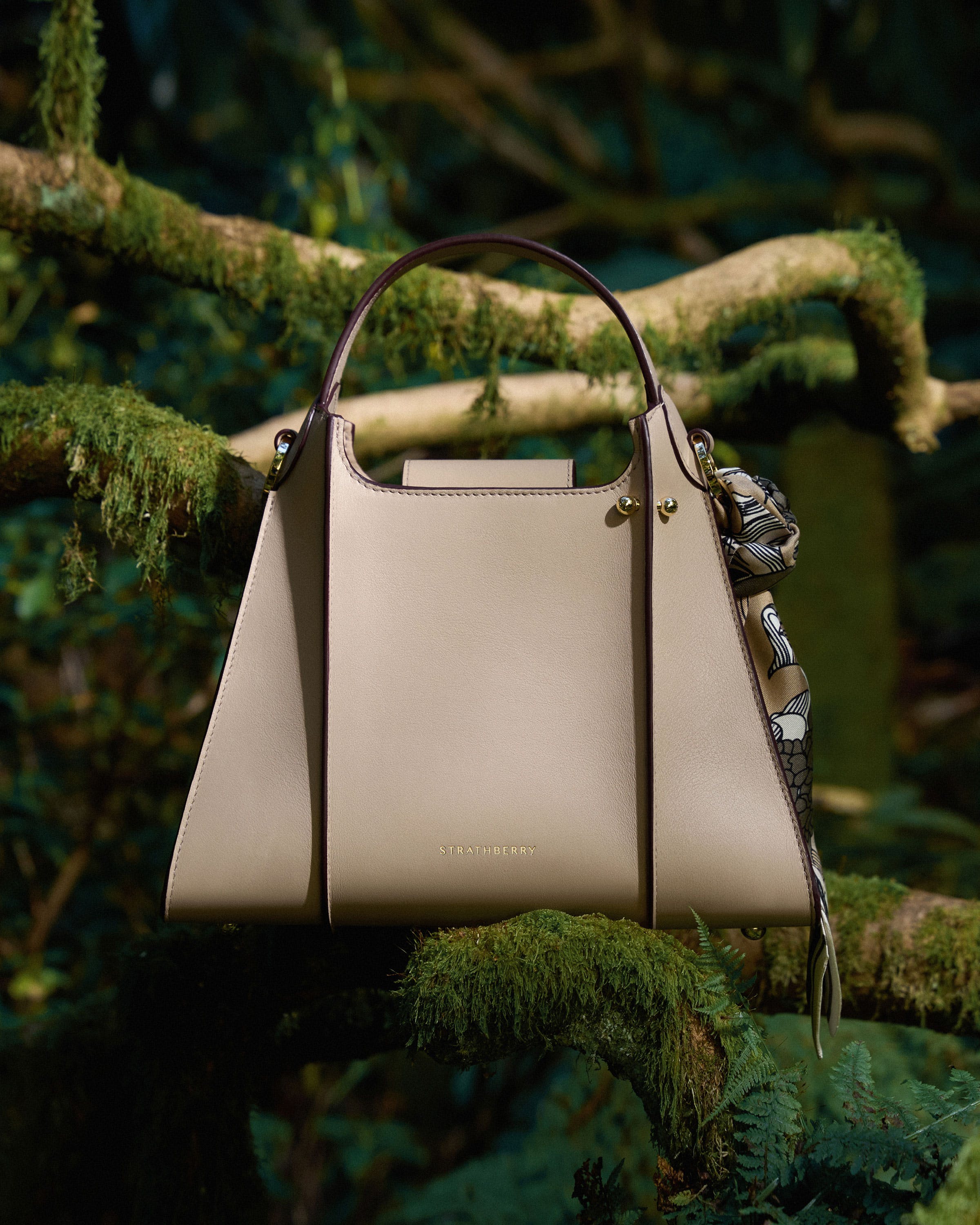 A white purse hanging from a tree branch