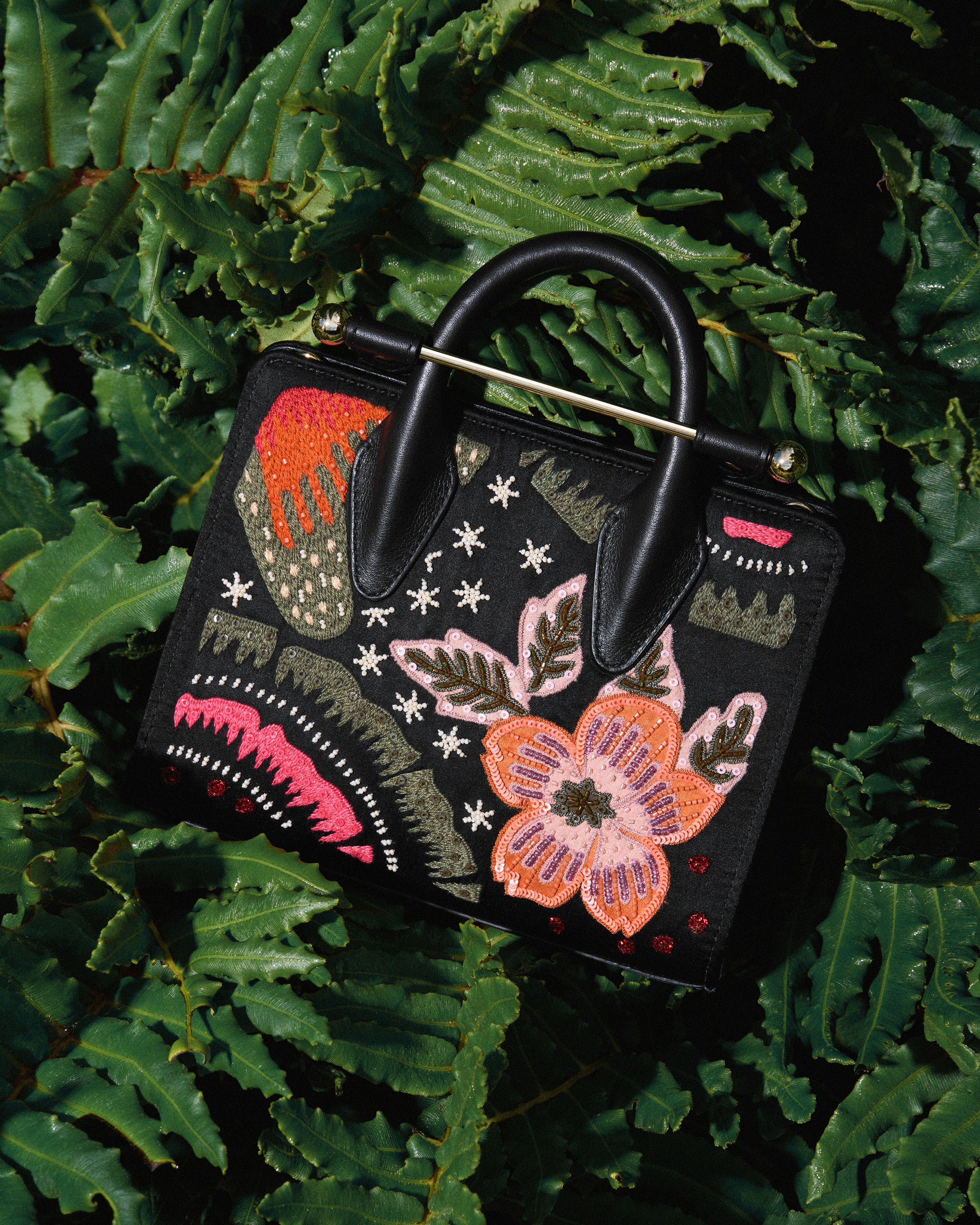 A black purse with a floral design on it