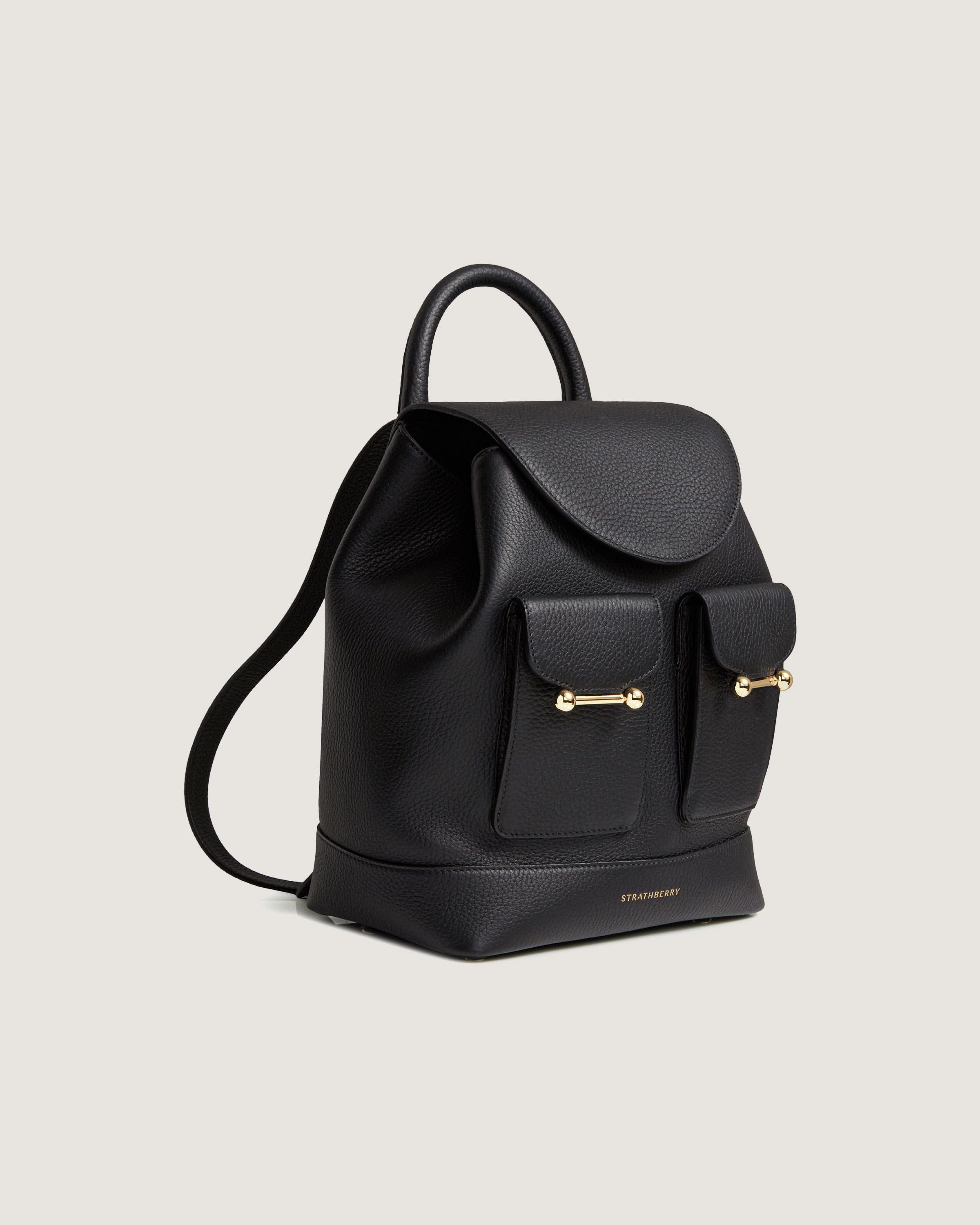 A black leather backpack with a gold zipper