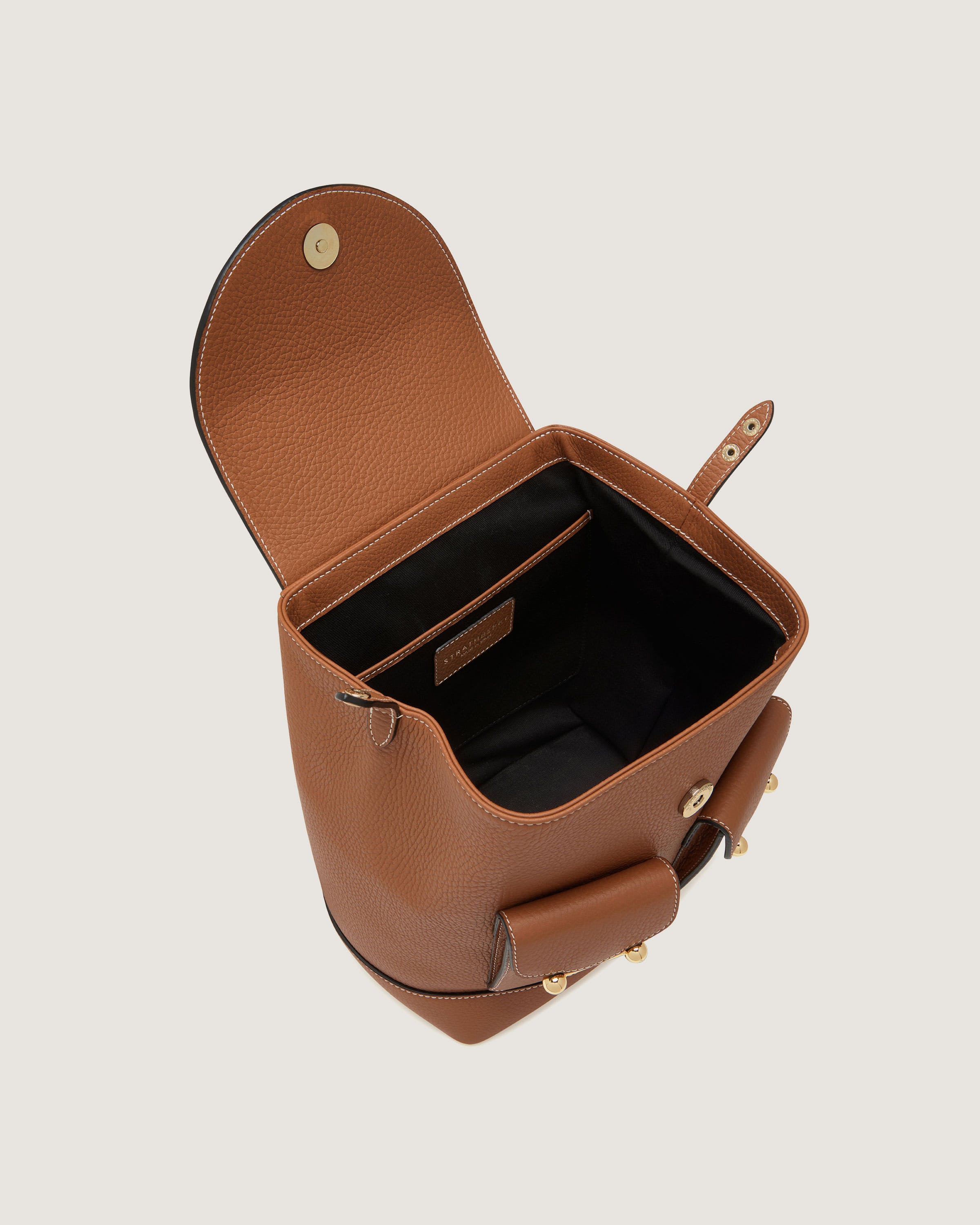 A brown leather purse with a phone inside of it