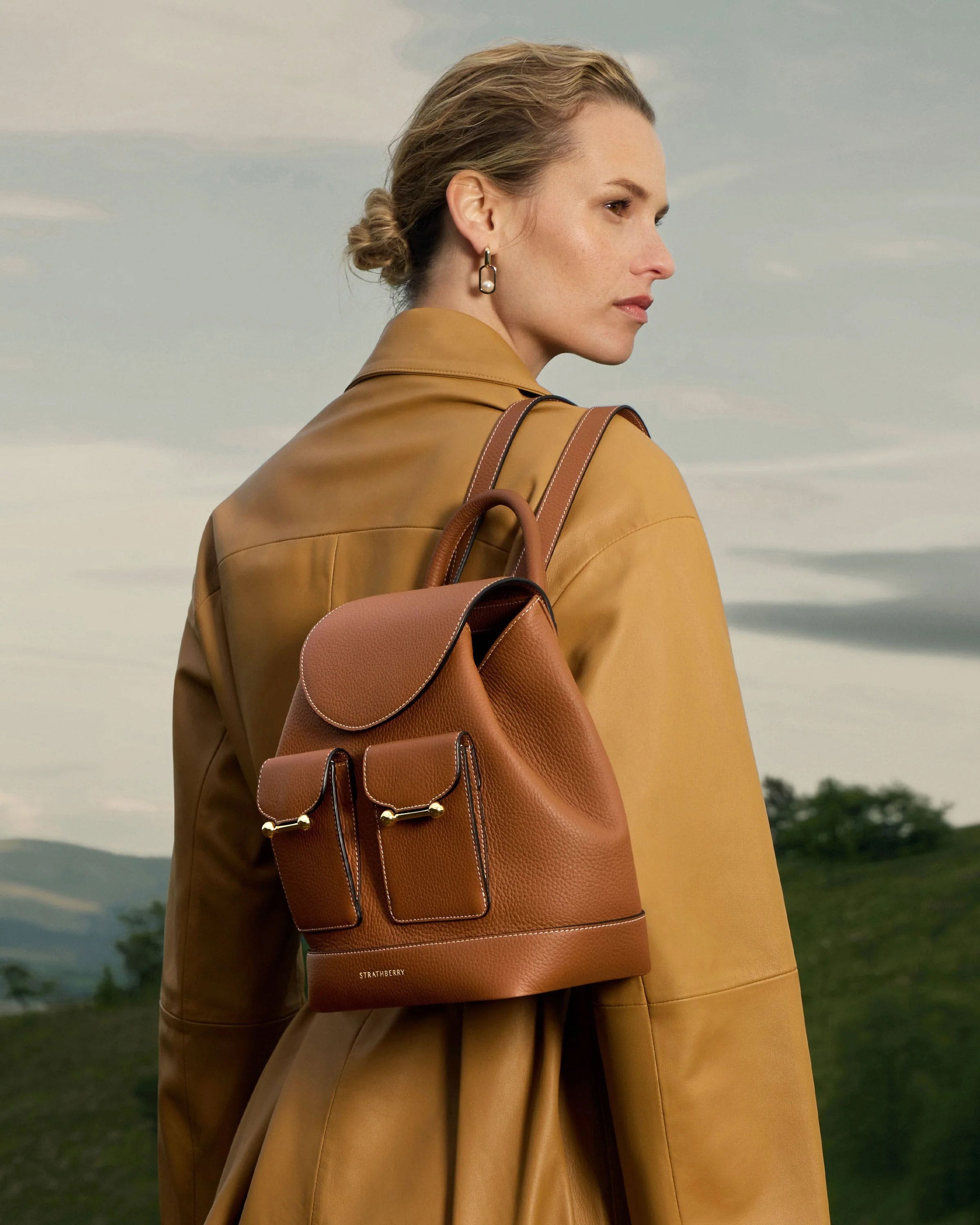 A woman wearing a brown leather backpack