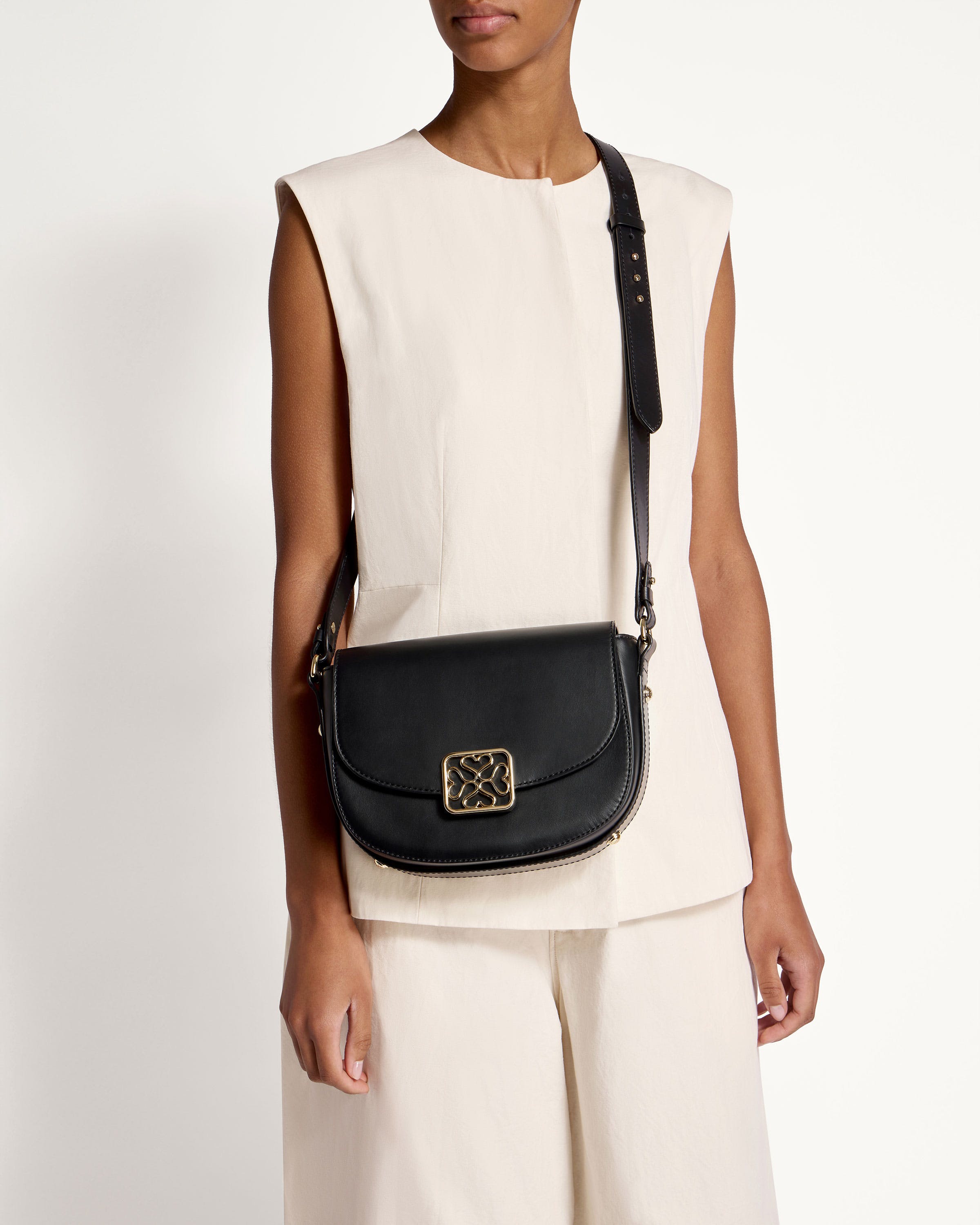 A woman wearing a white top and a black cross body bag