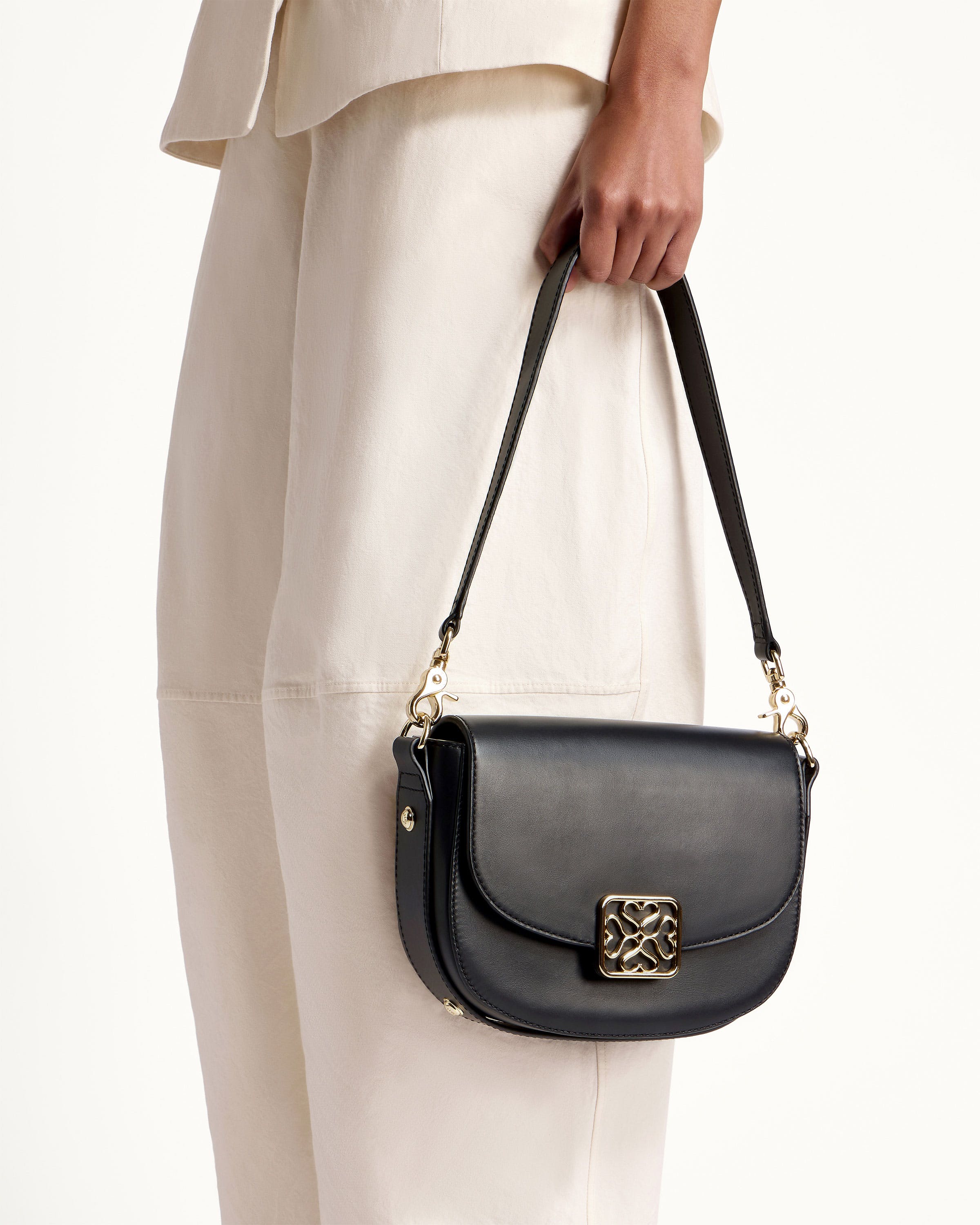 A woman is holding a black purse