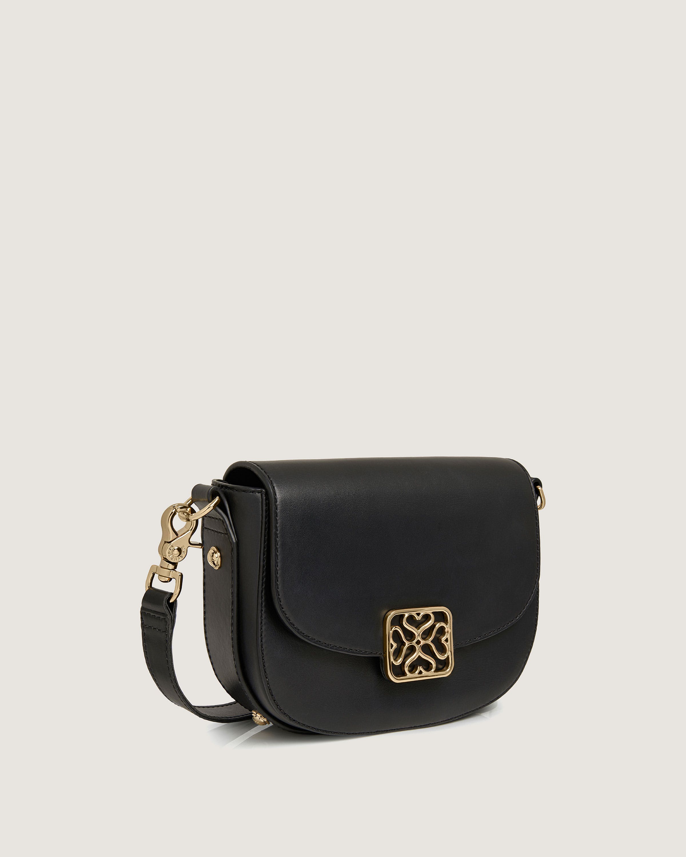 A black cross body bag with a gold buckle