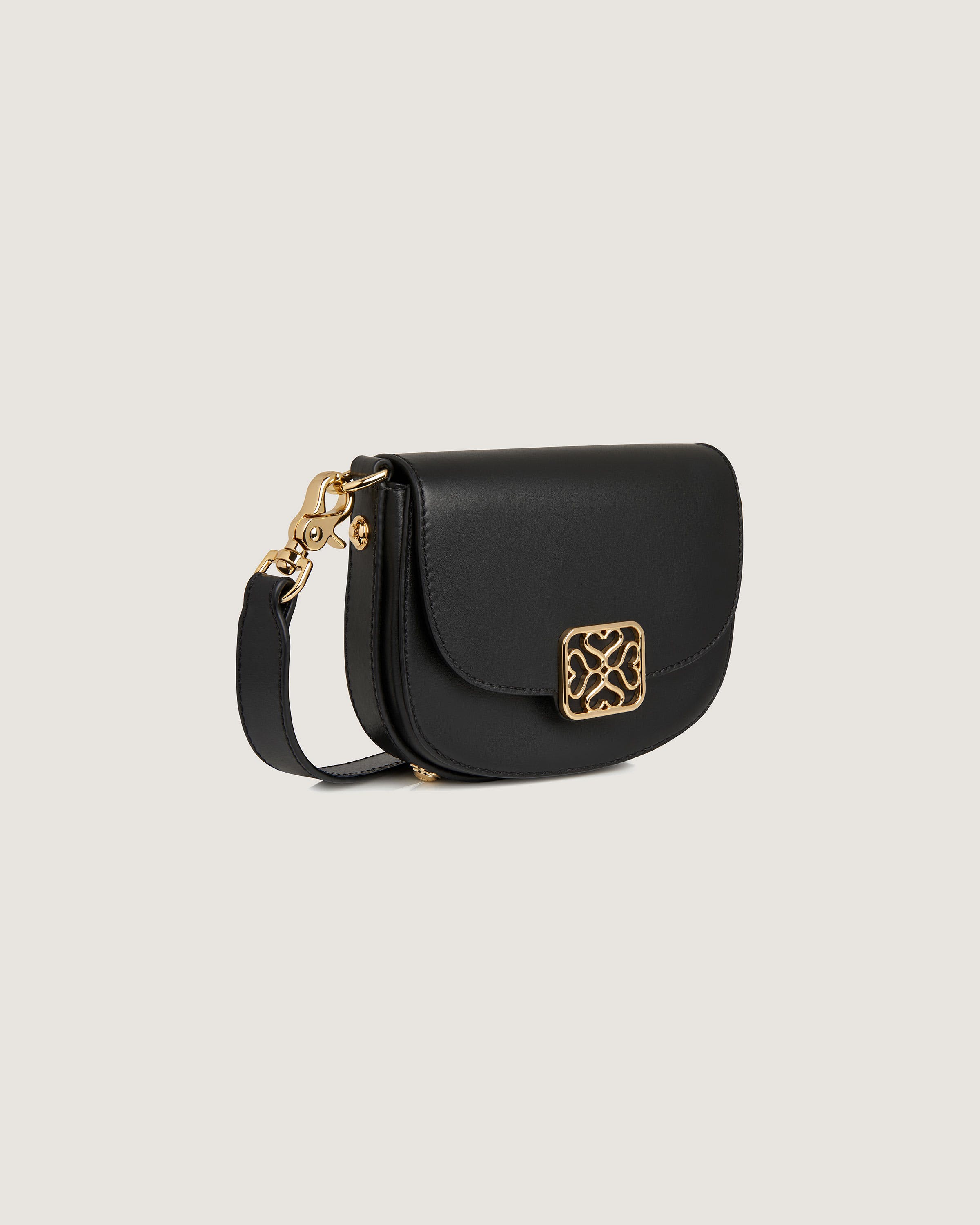 A black cross body bag with a gold buckle