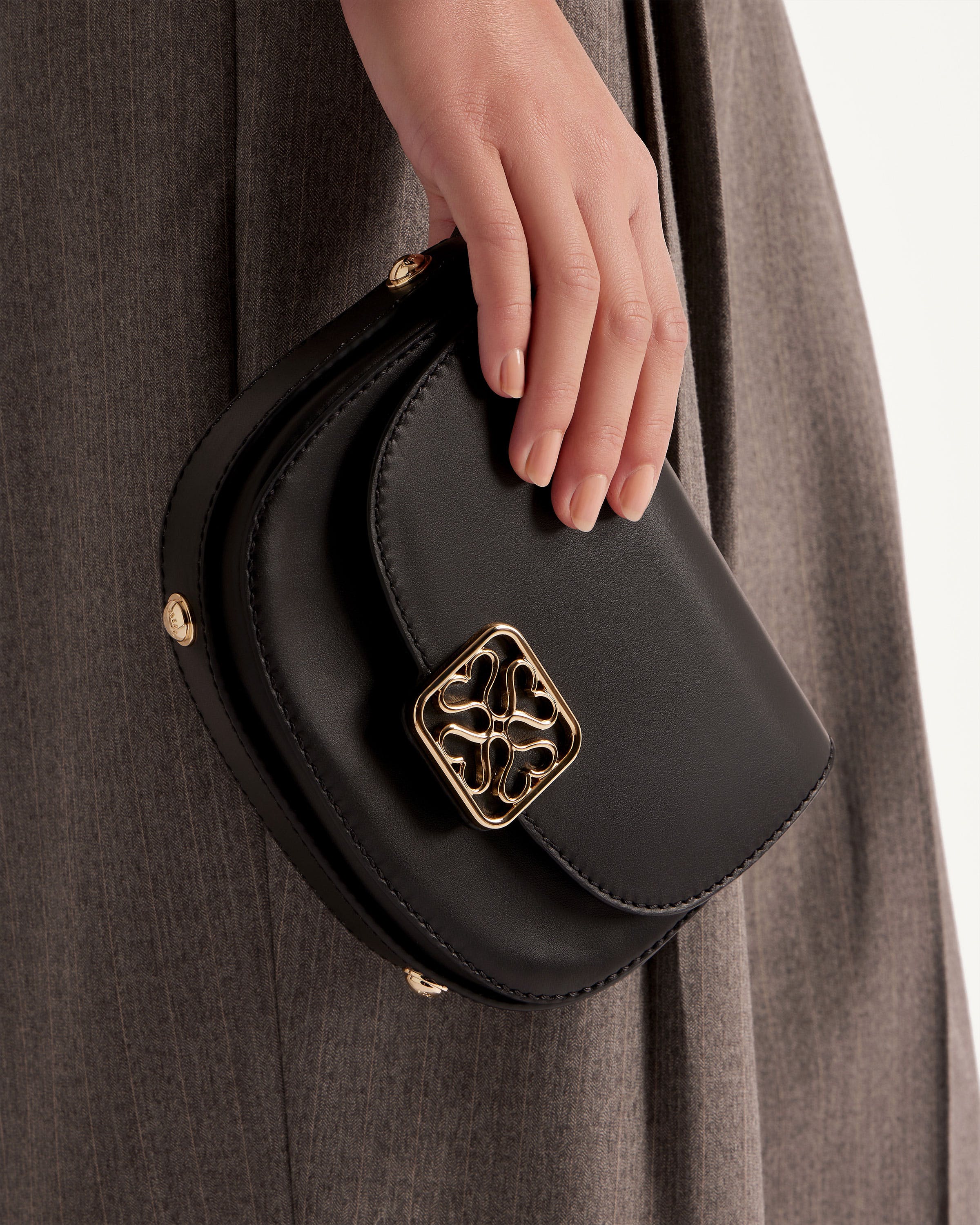 A woman's hand holding a black purse