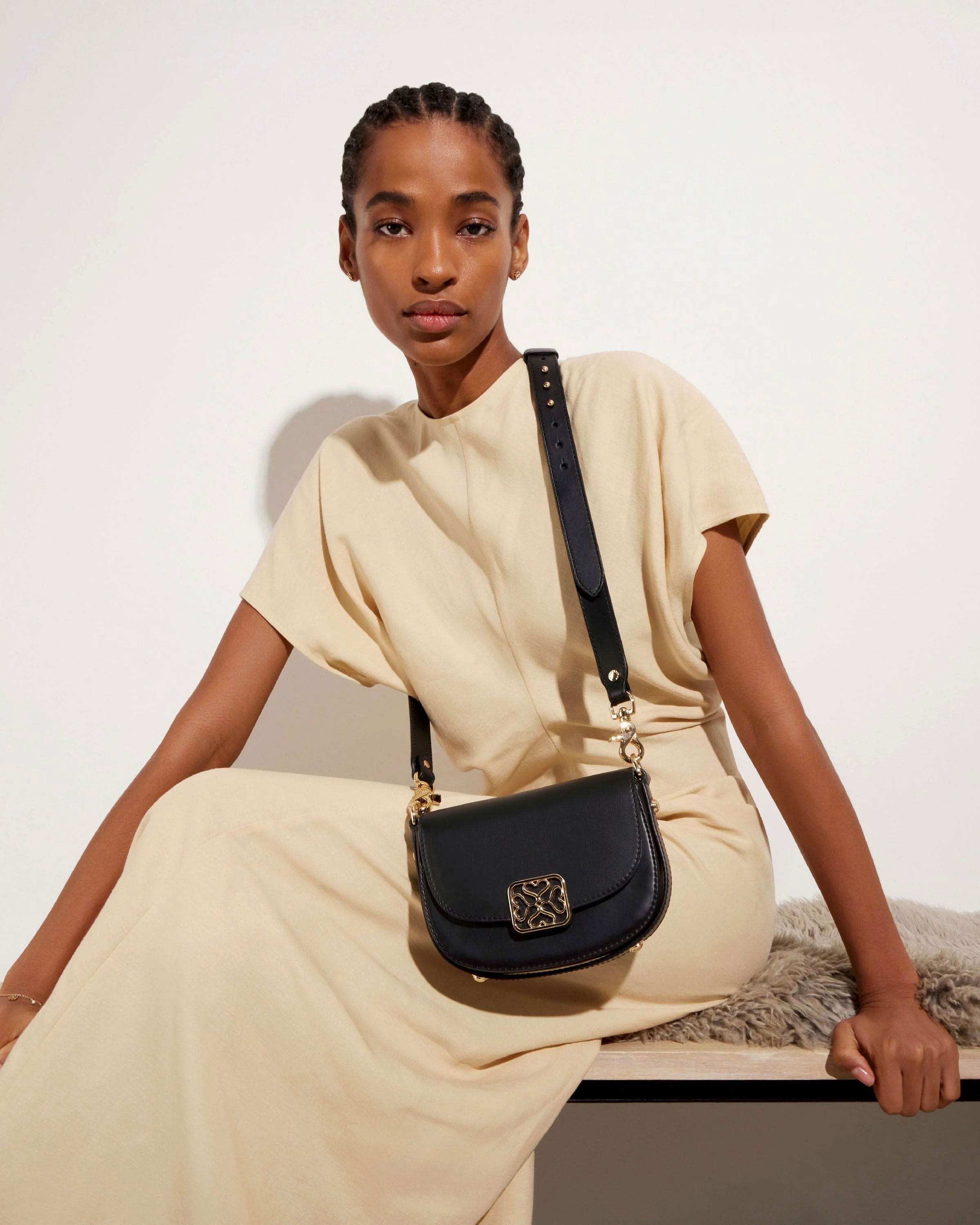 A woman sitting on a bench with a black purse