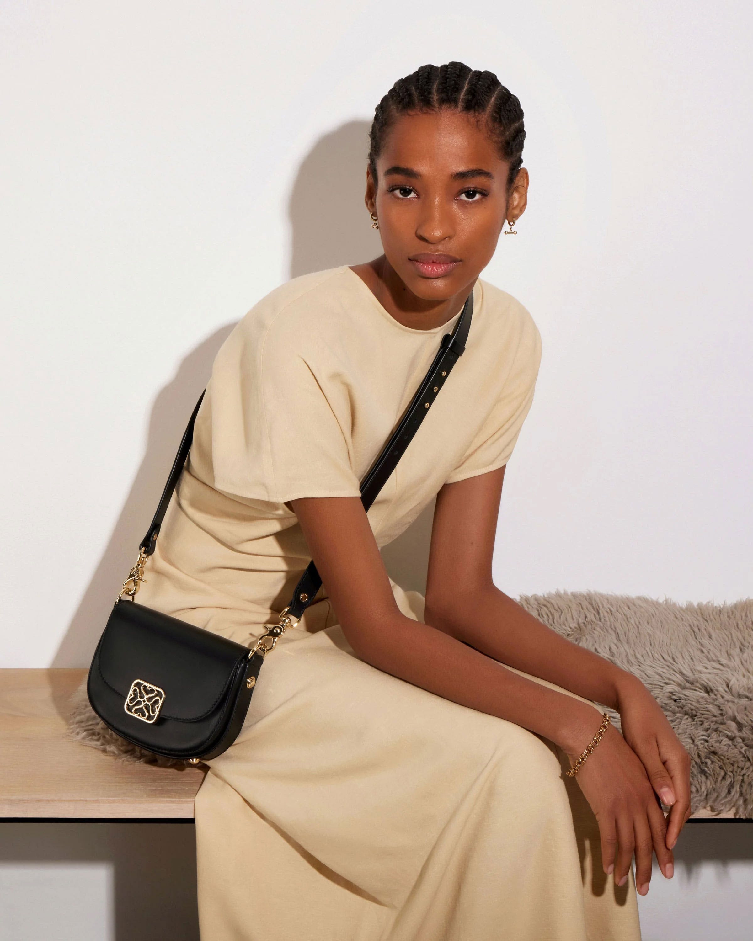 A woman sitting on a bench holding a black purse