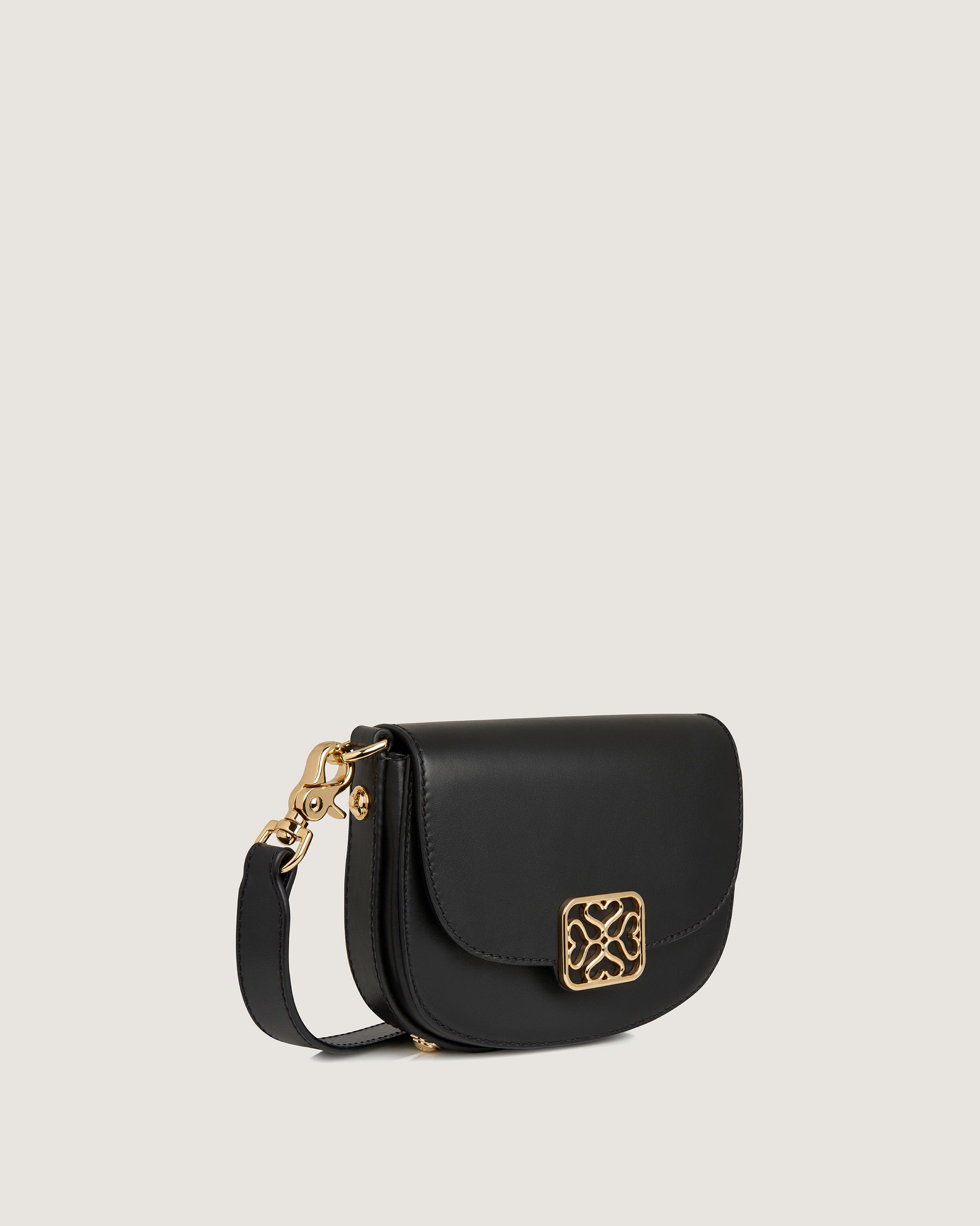 A black cross body bag with a gold buckle