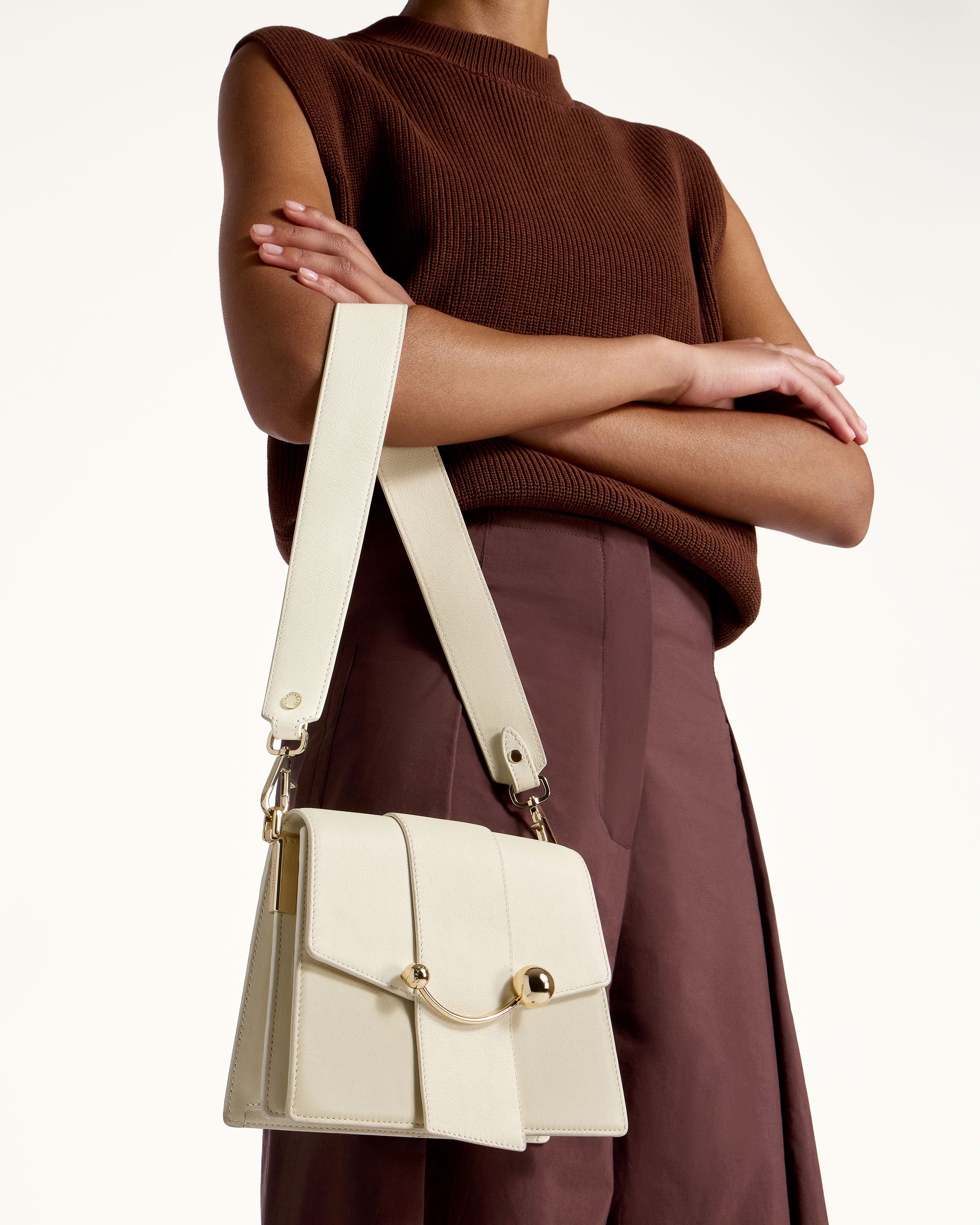 A woman is holding a white purse