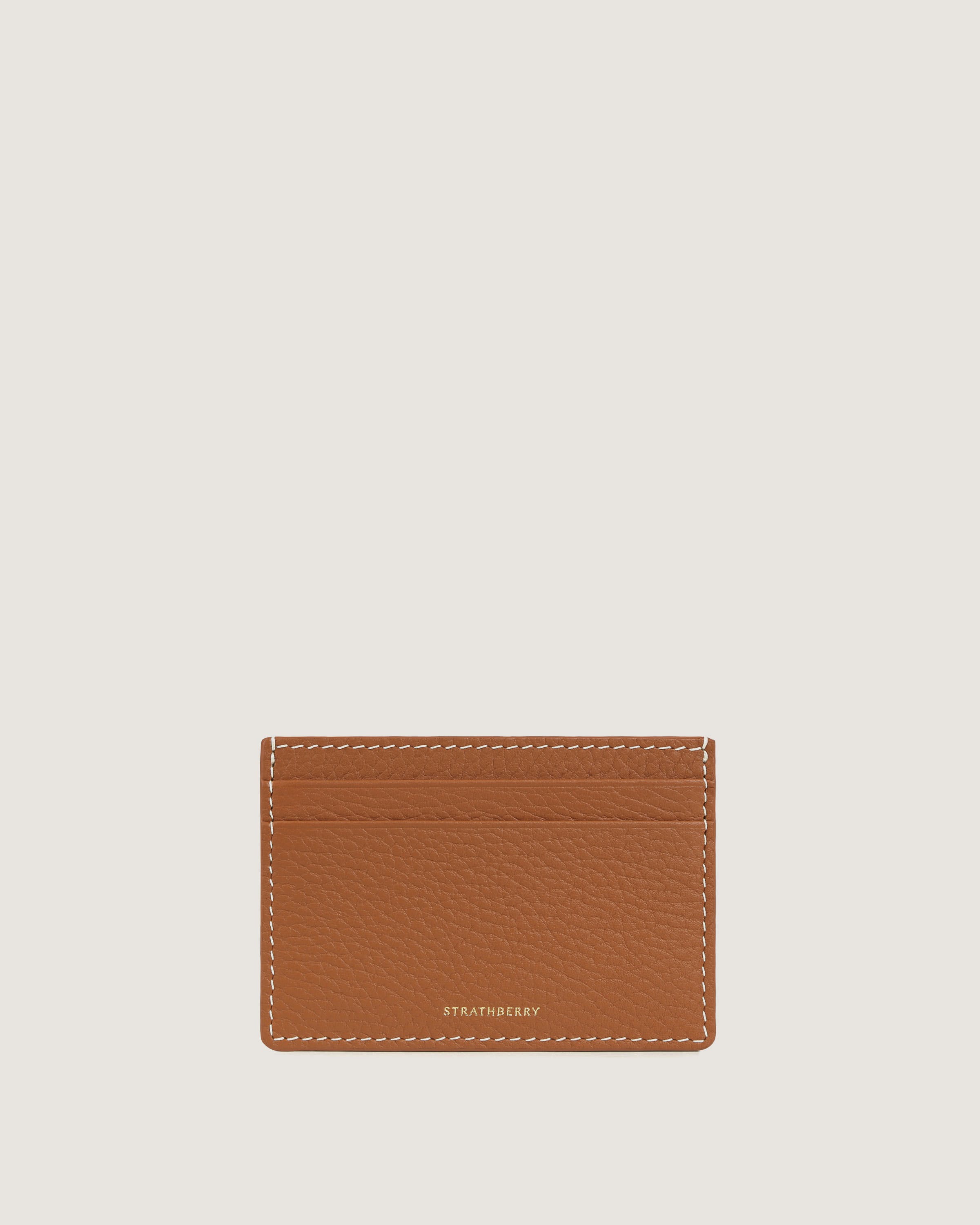 A tan leather card case on a white background