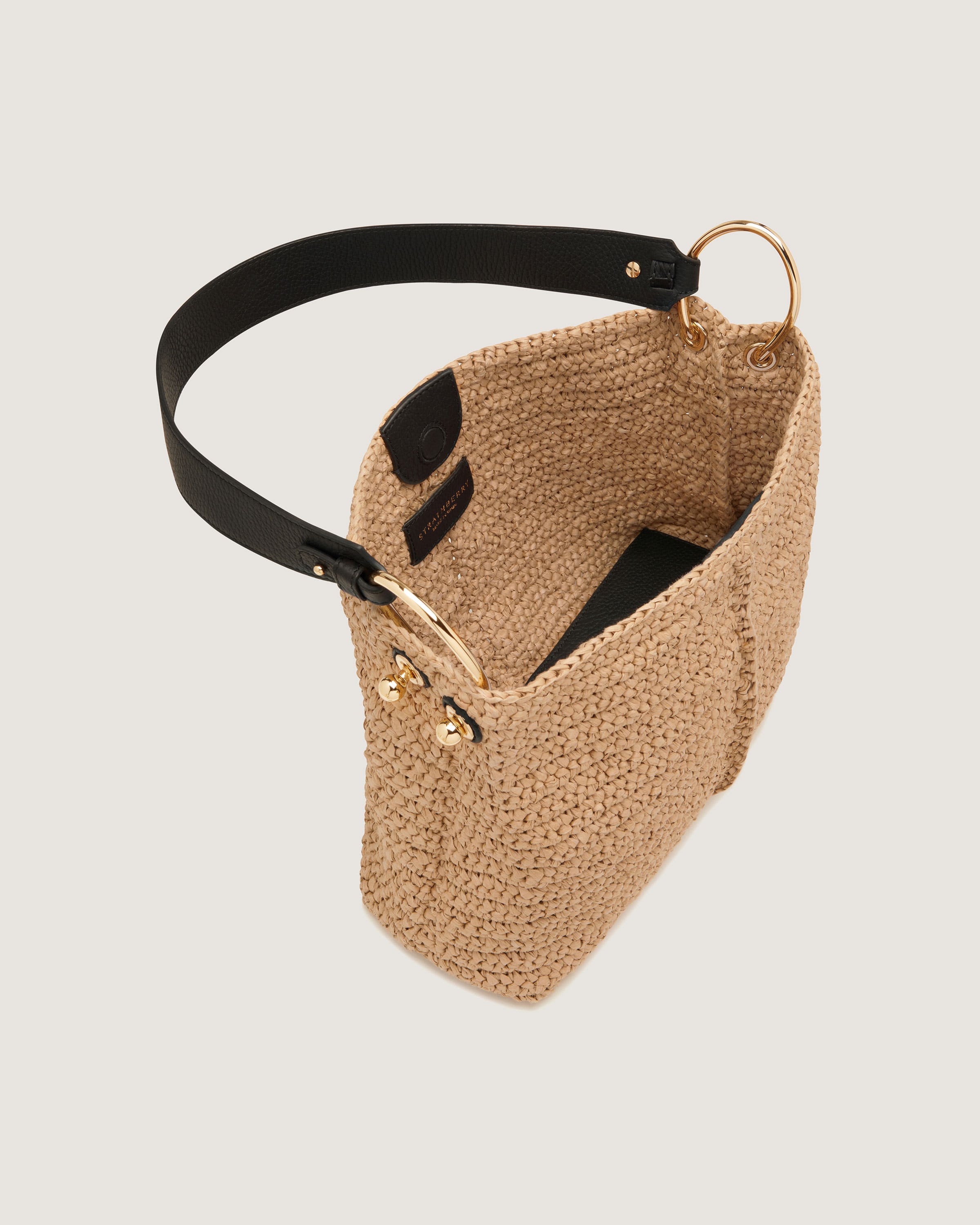 A straw bag with a black leather handle