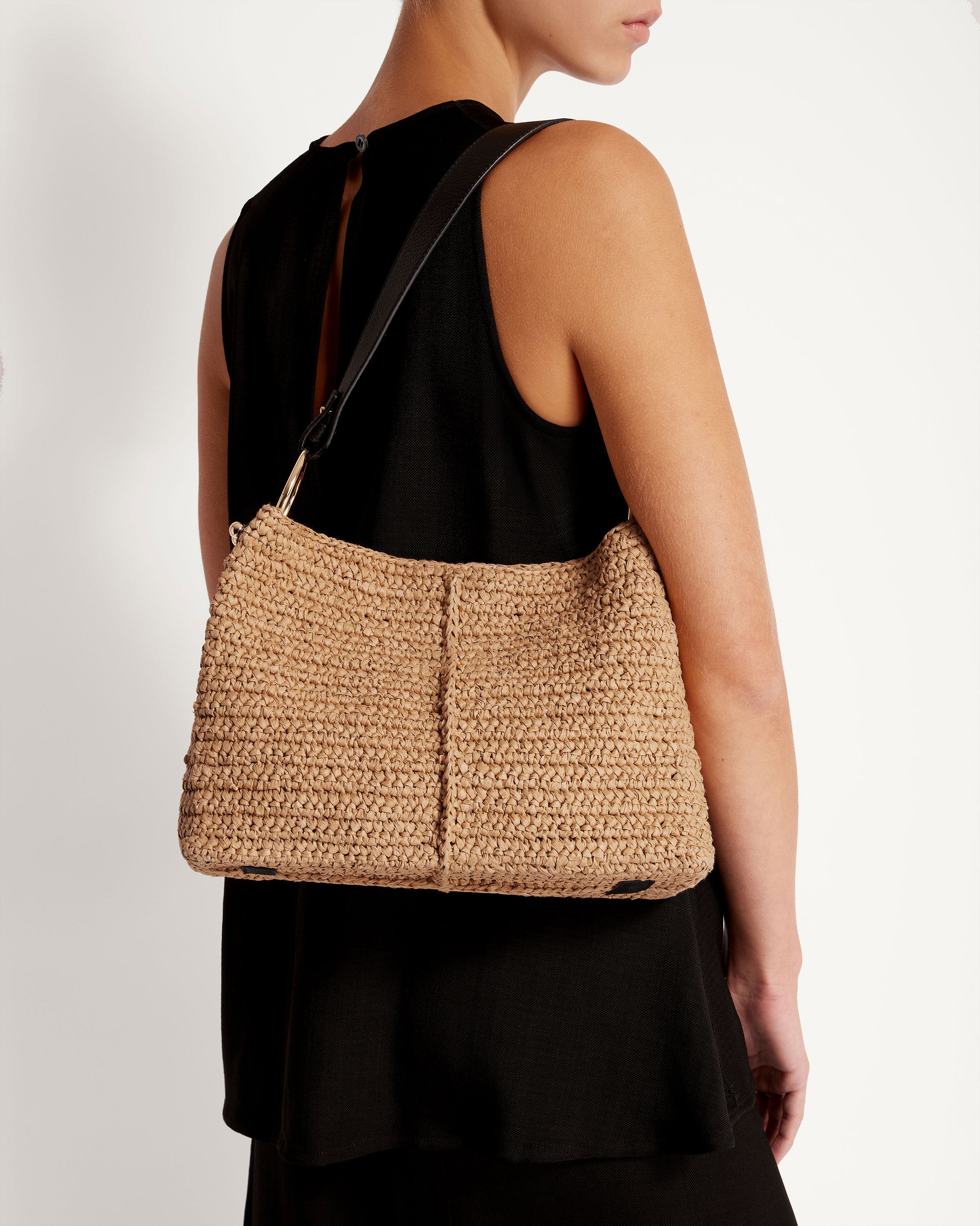 A woman carrying a straw bag on her shoulder