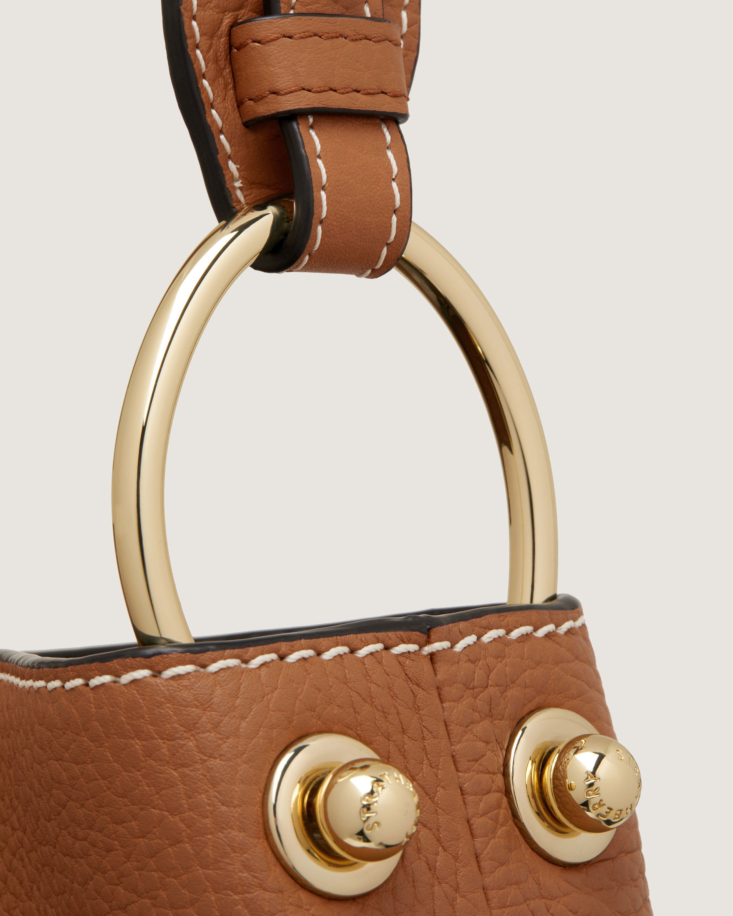 A brown handbag with a gold handle