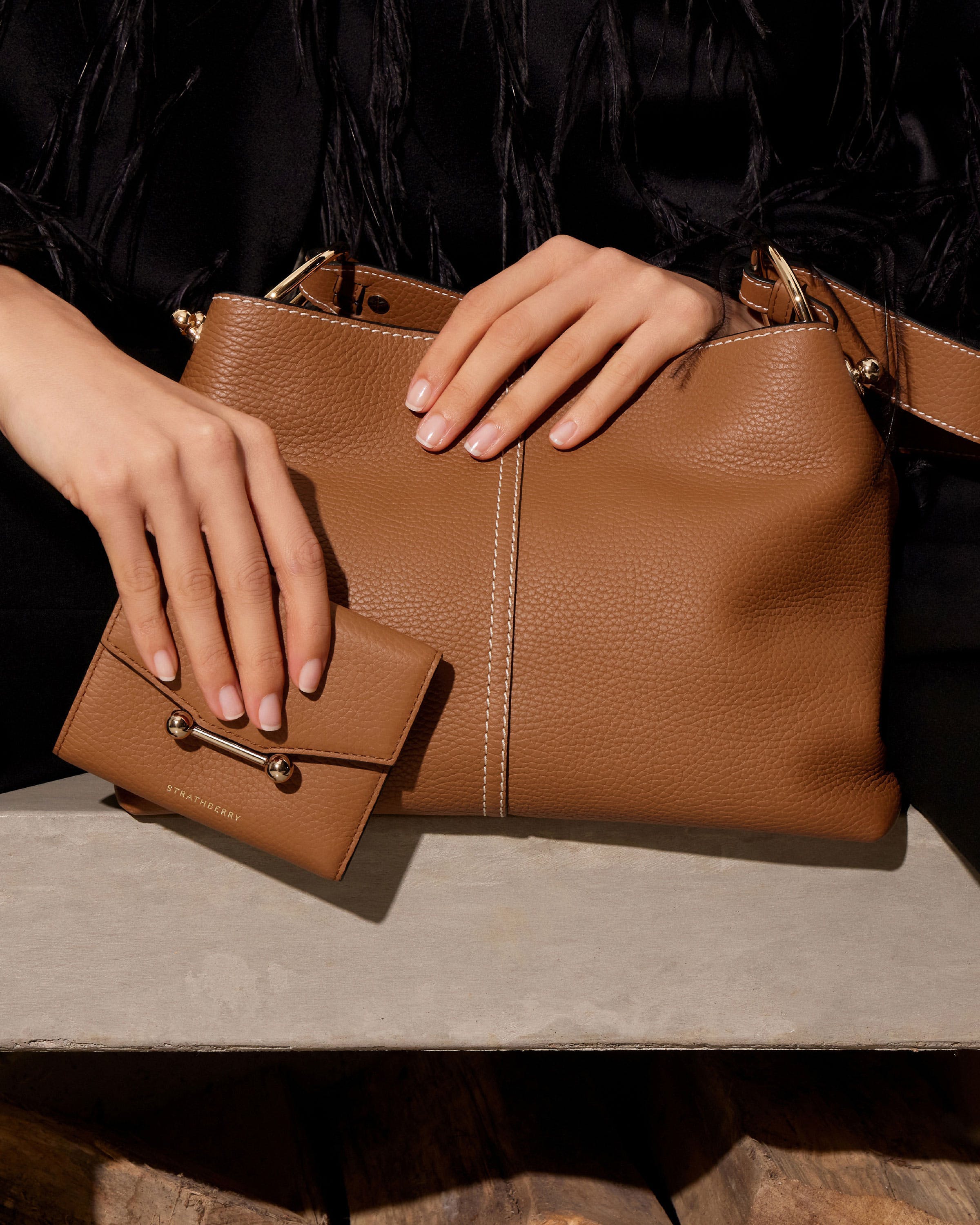 A woman's hand holding a brown purse