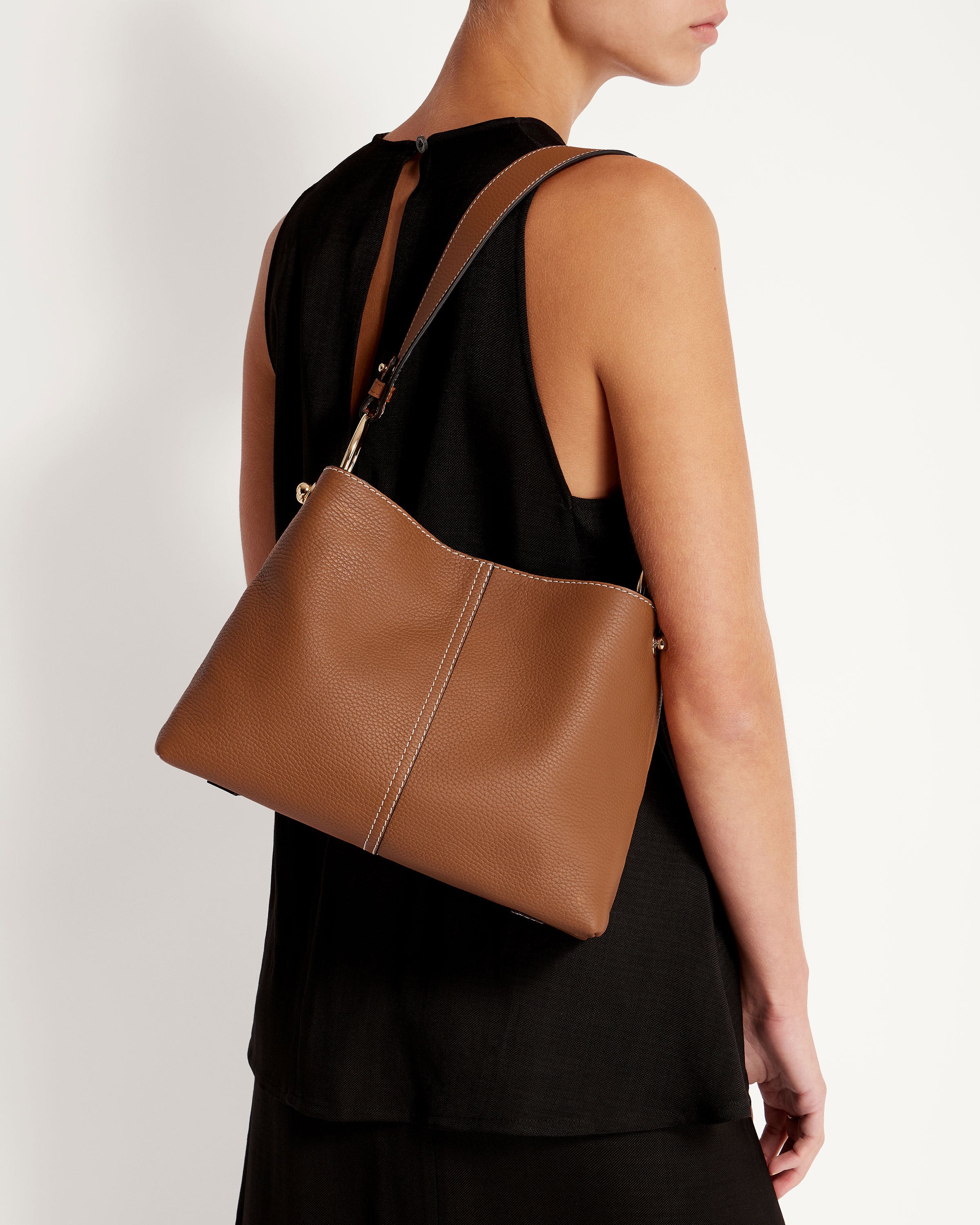 A woman is holding a brown purse