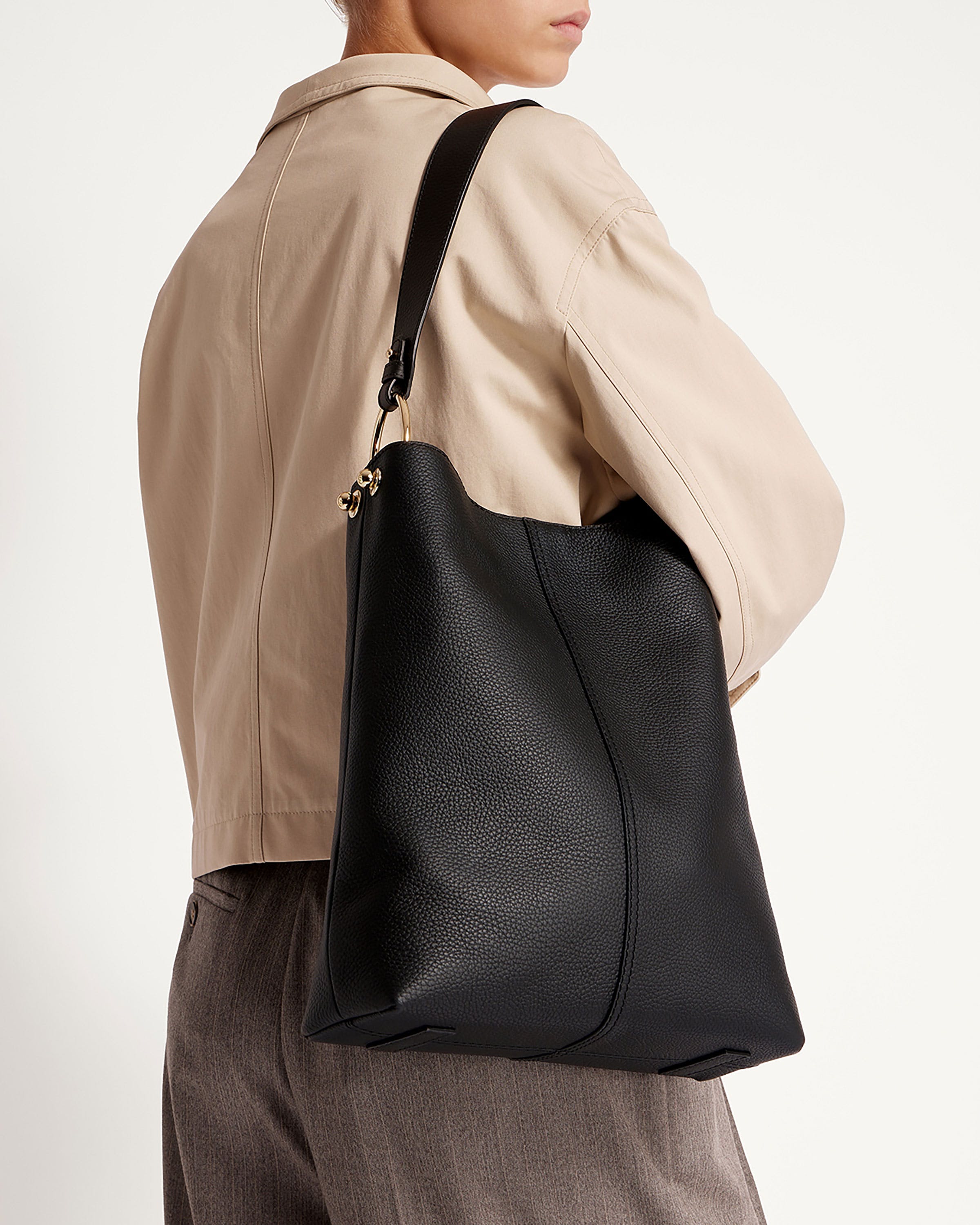 A woman carrying a black leather tote bag