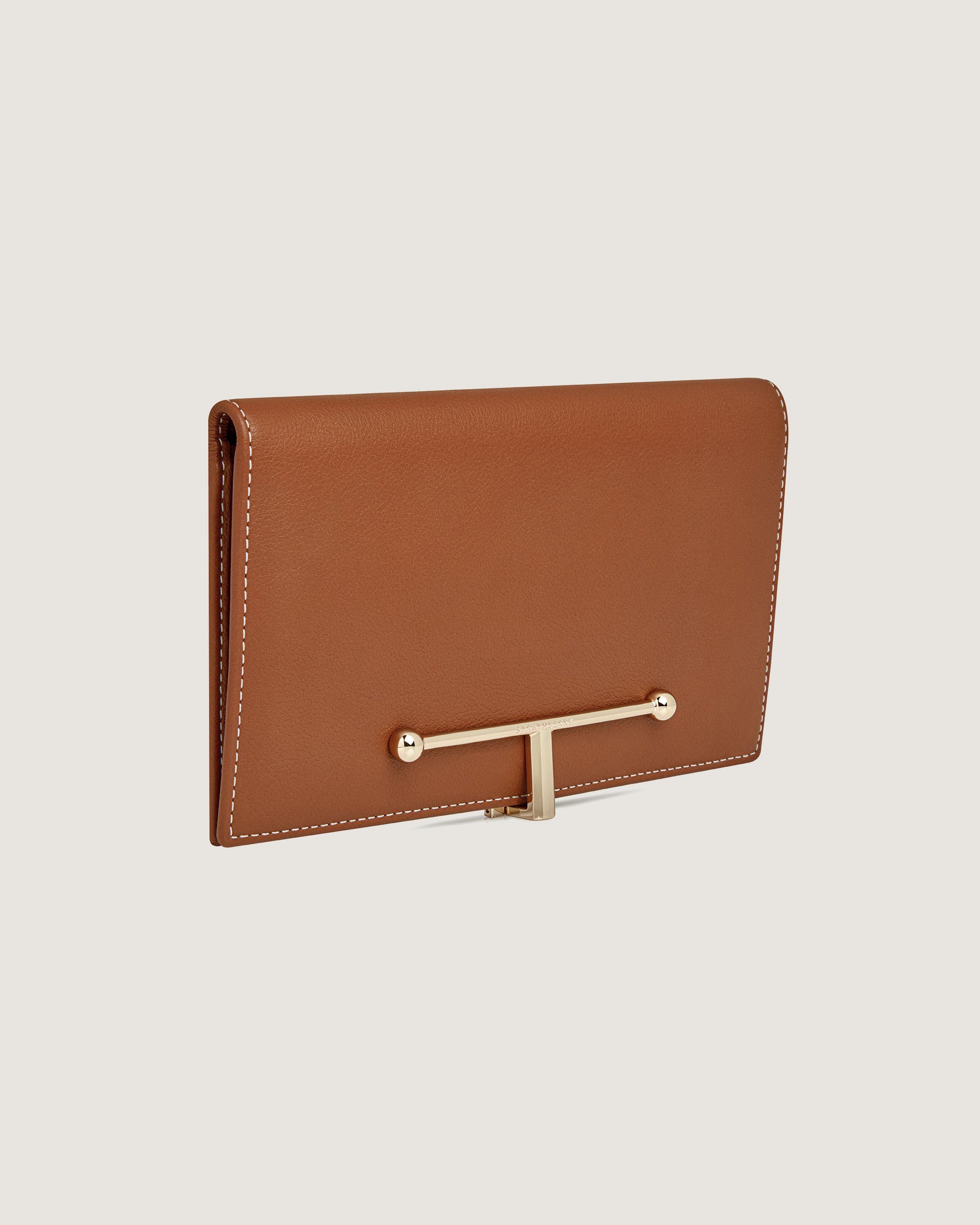 A brown leather wallet with a gold bar on the front