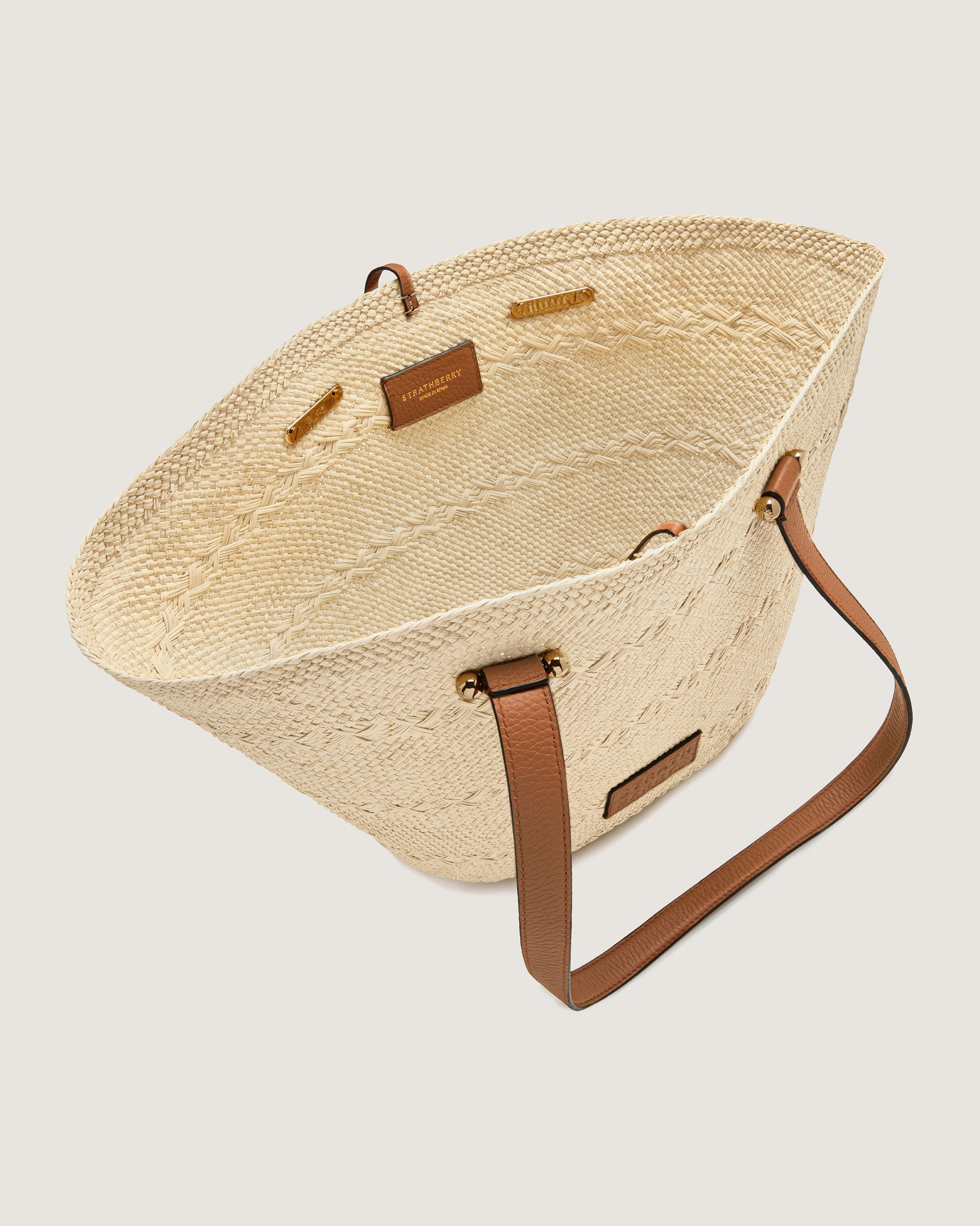 A straw bag with a brown leather handle