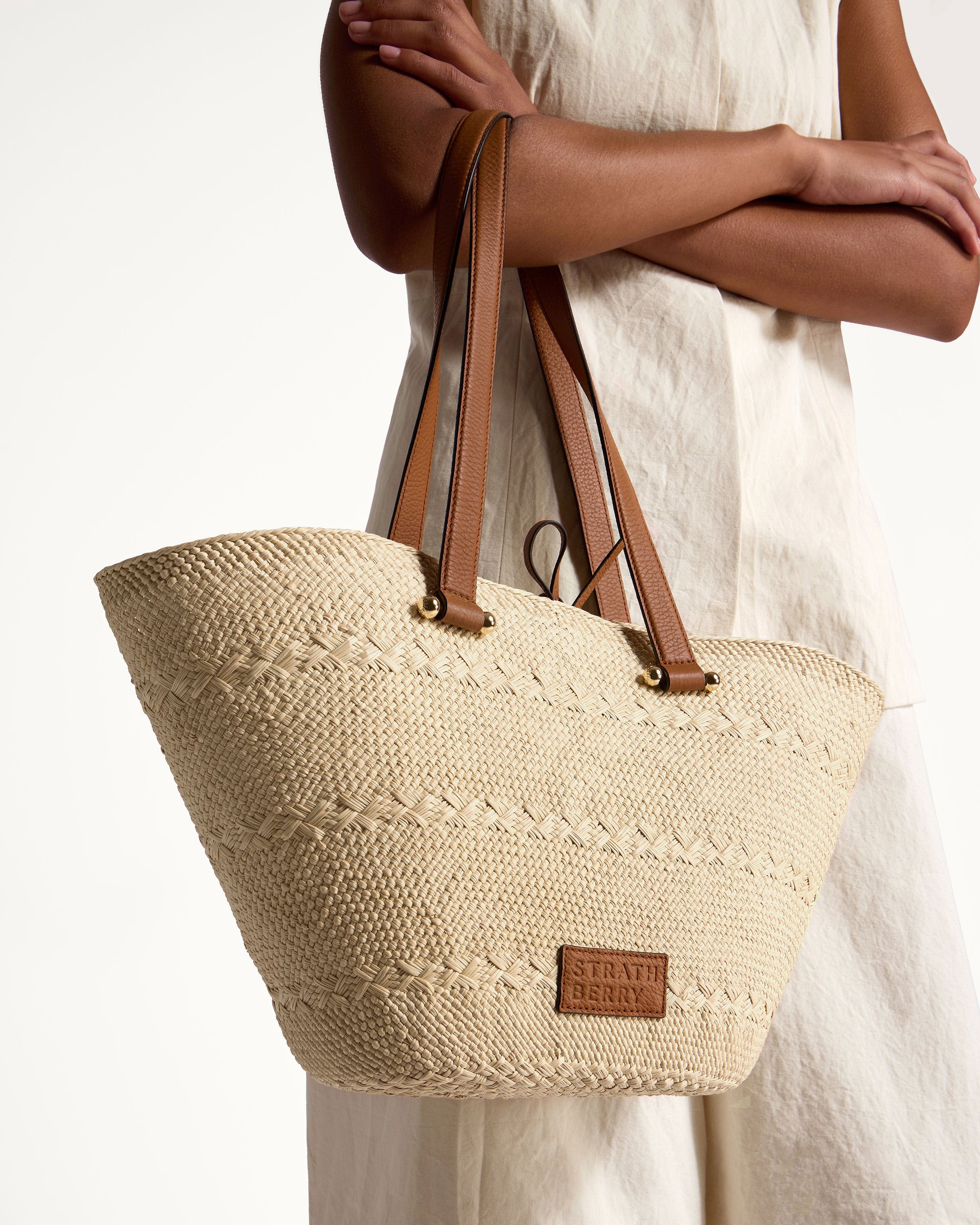 A woman is holding a large woven bag