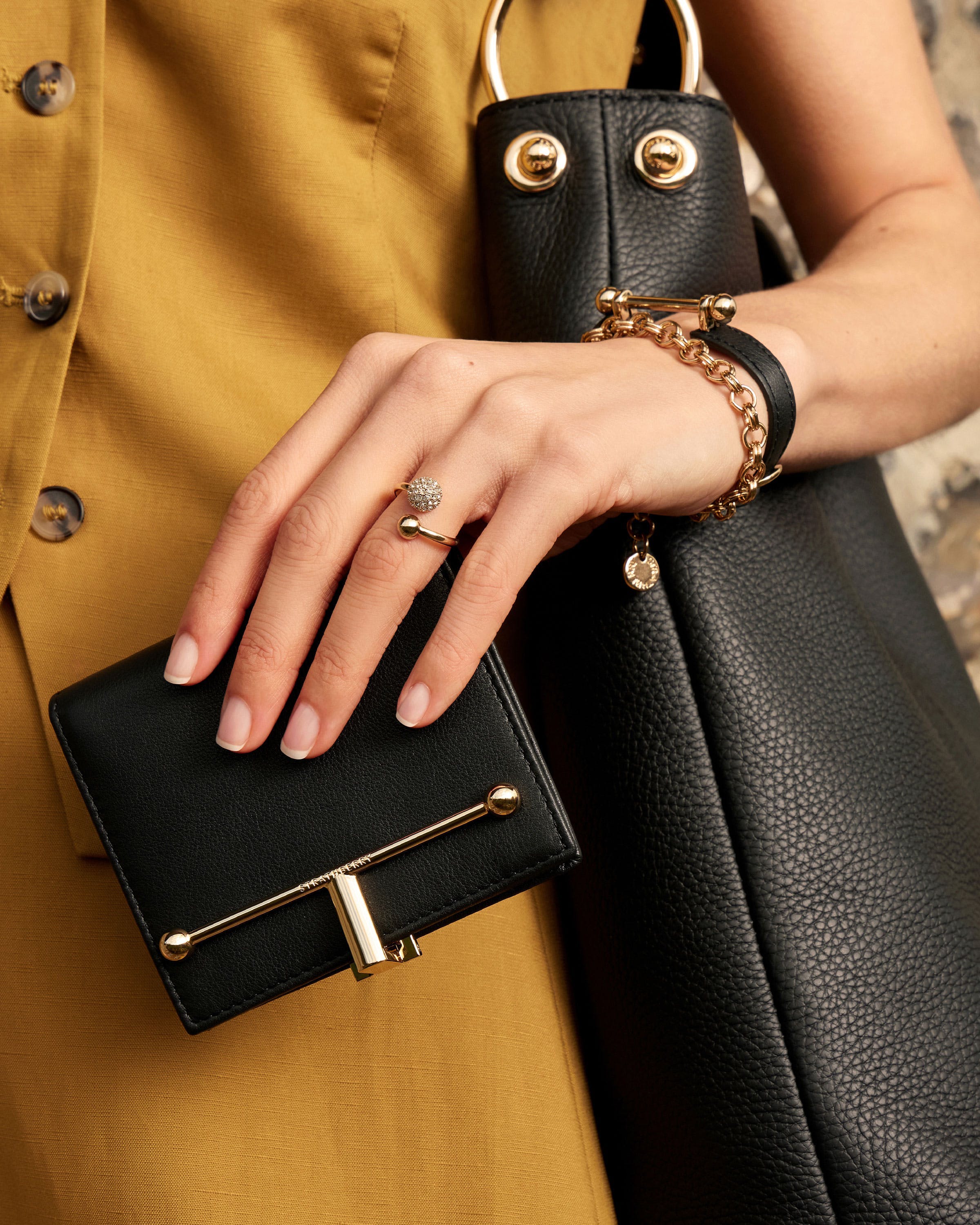 A woman's hand holding a black purse