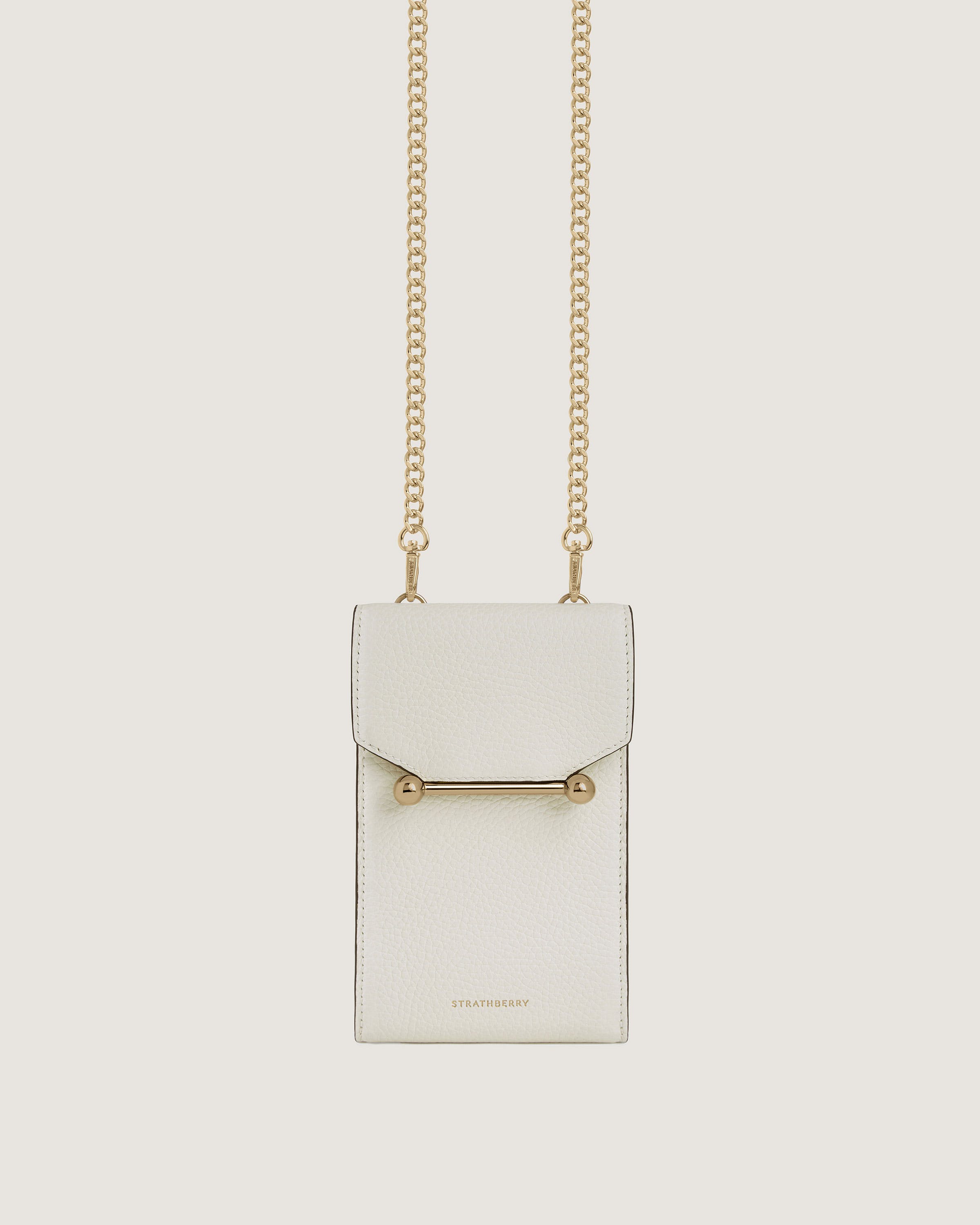 A white purse with a gold chain hanging from it