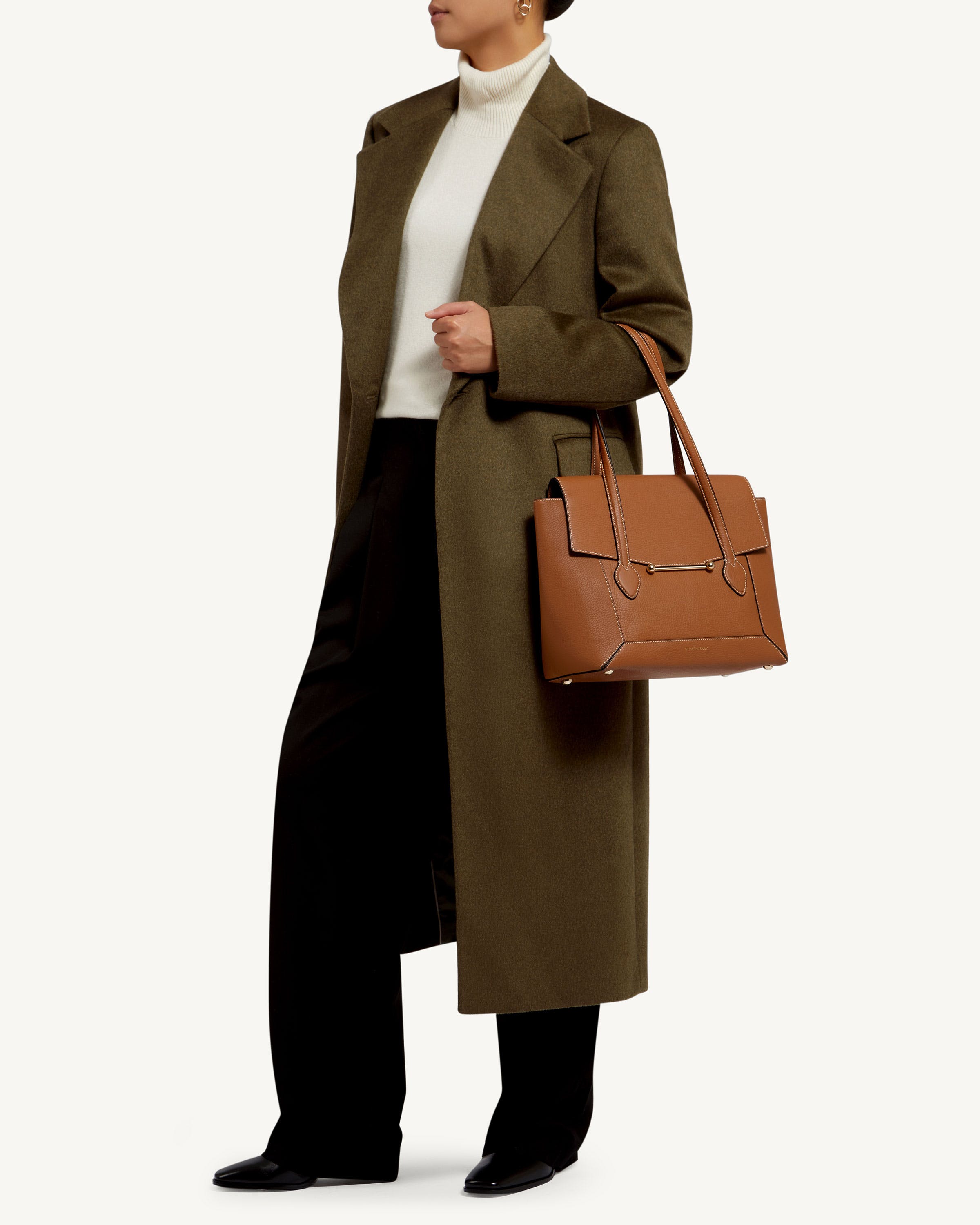 A woman holding a brown bag and a brown purse