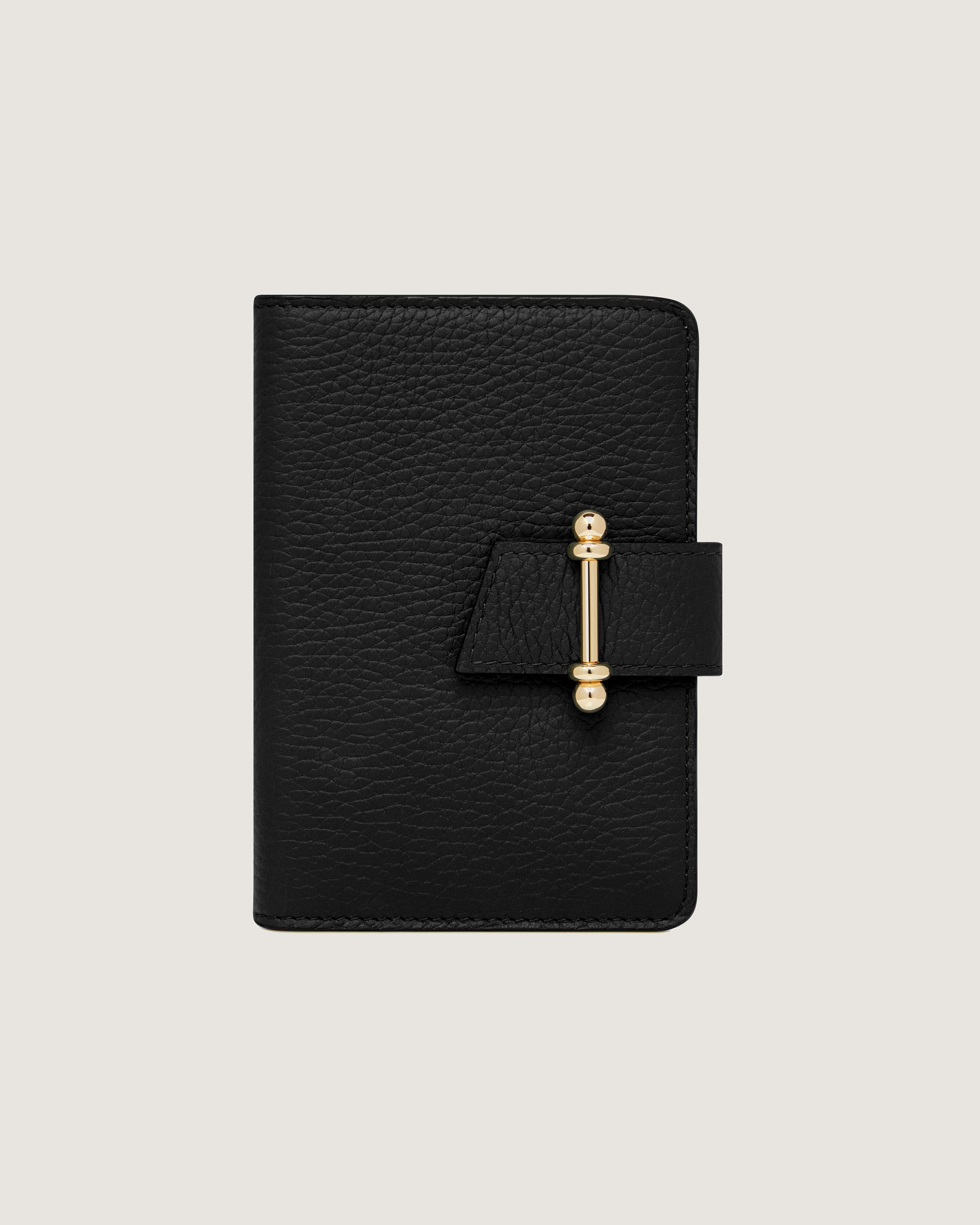 A black passport case with a gold bar on the front