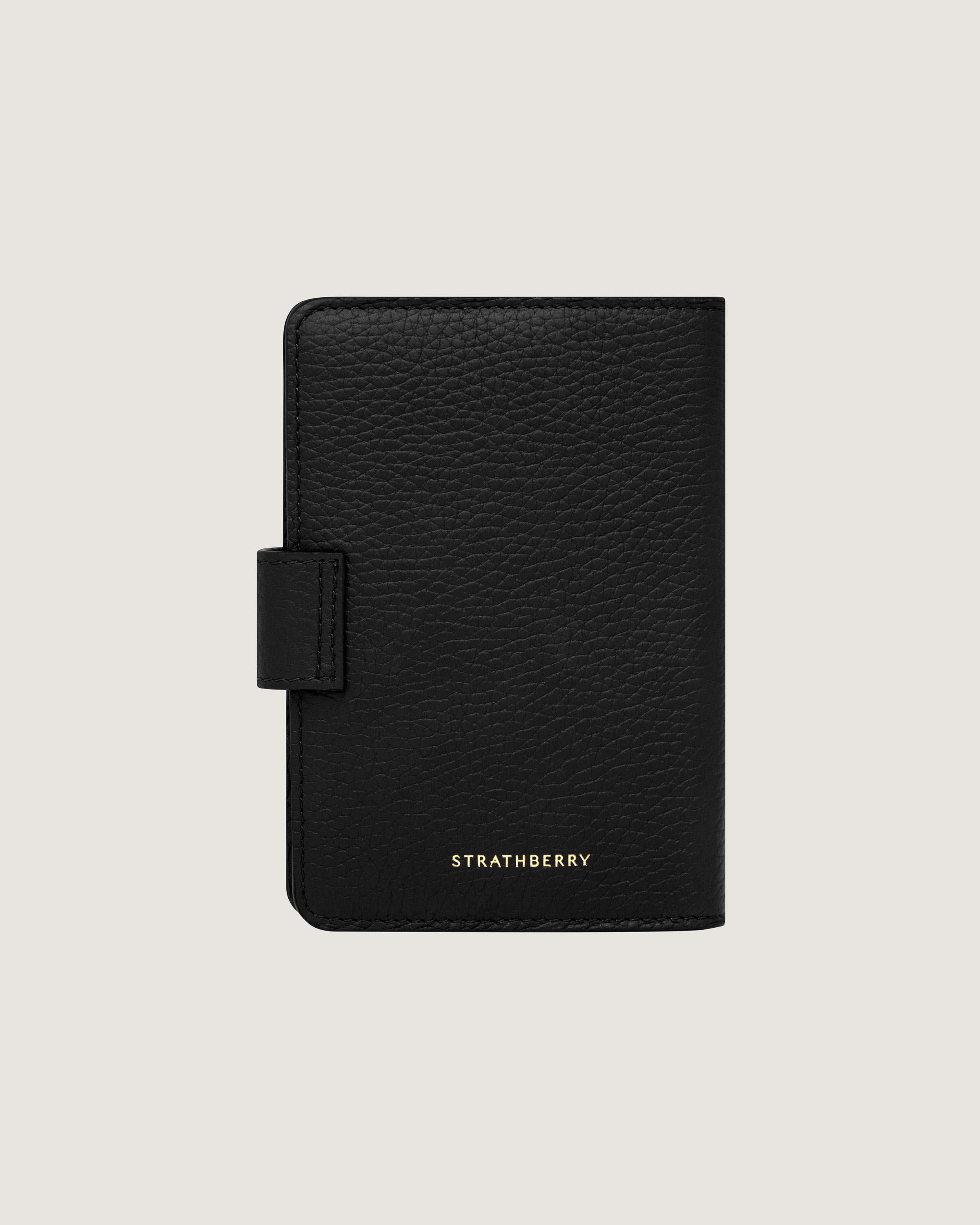 A black leather passport case with a gold logo