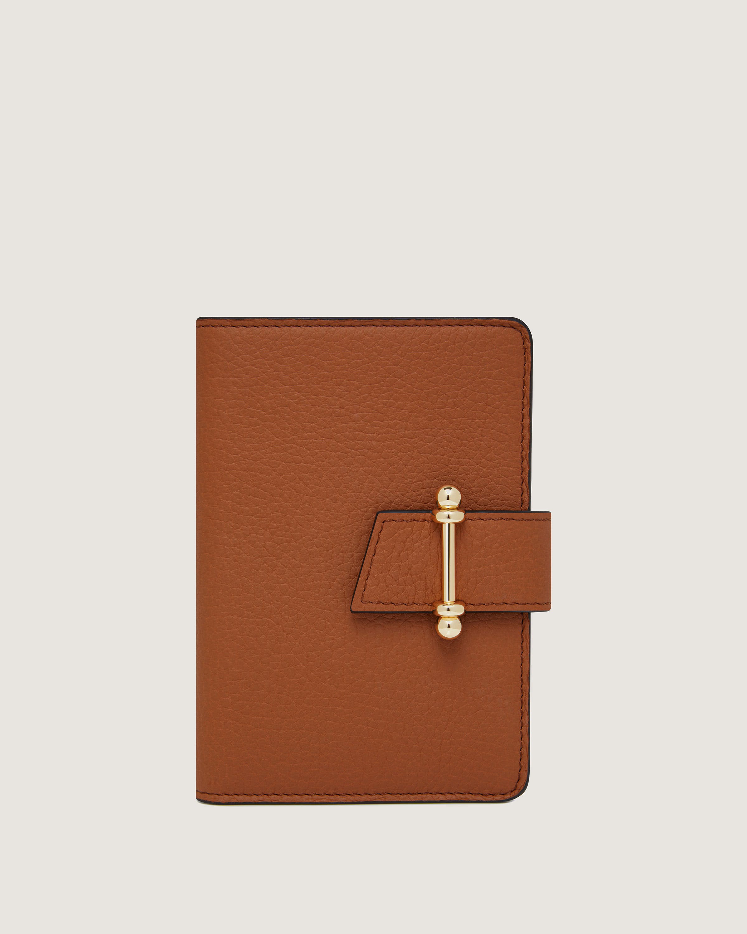 A brown leather notebook with a gold clasp