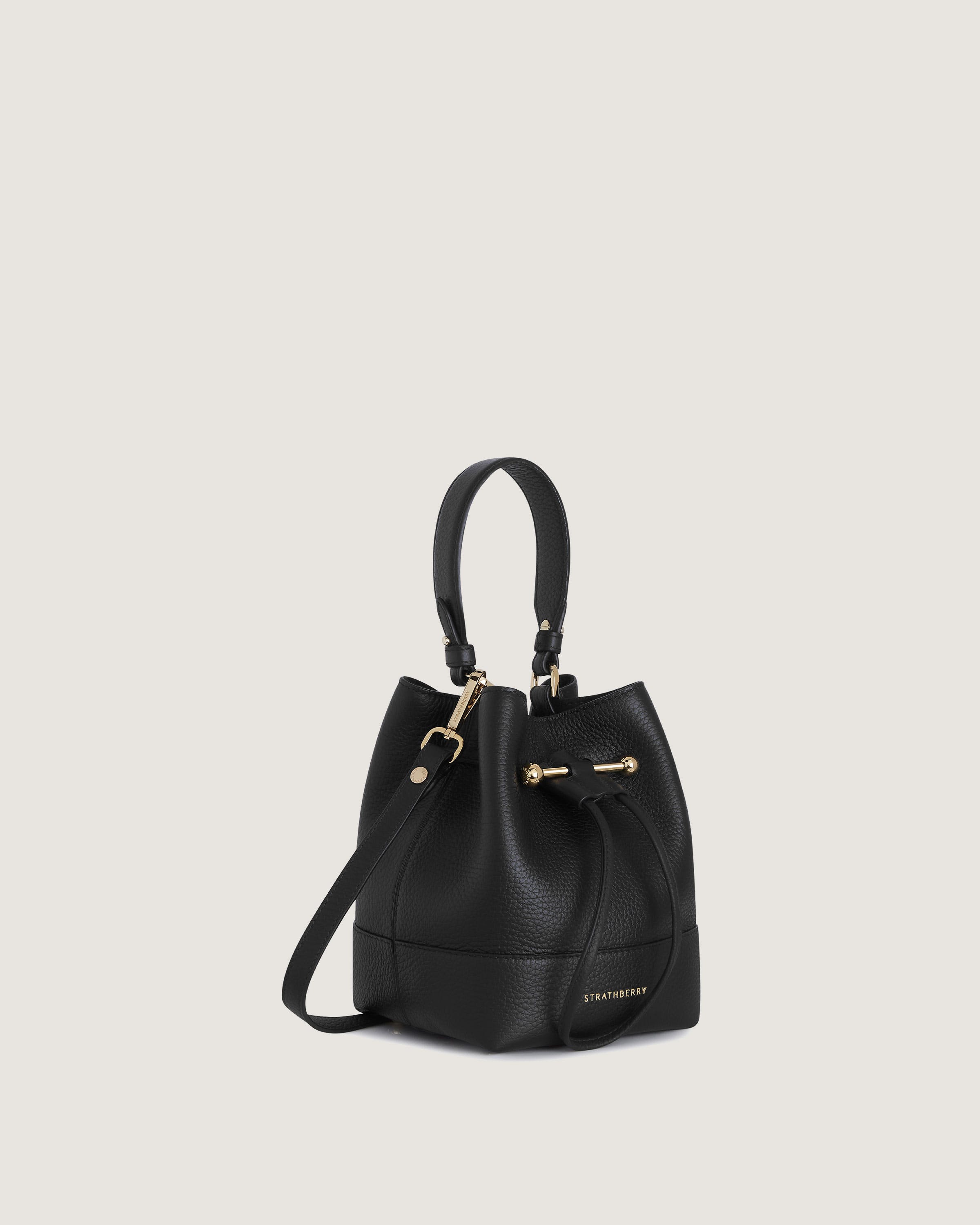 A black handbag with a gold handle