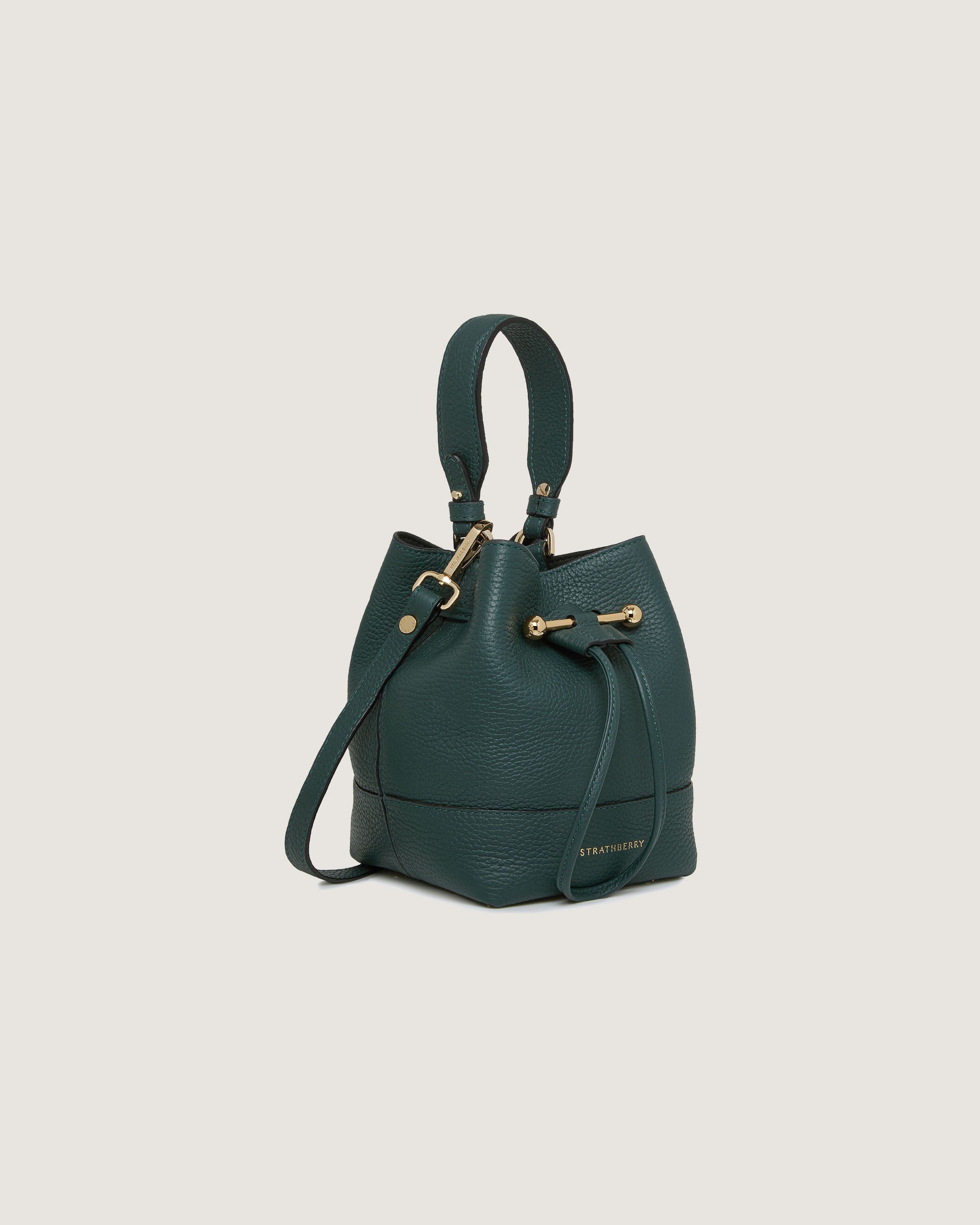 A green bucket bag with a gold handle