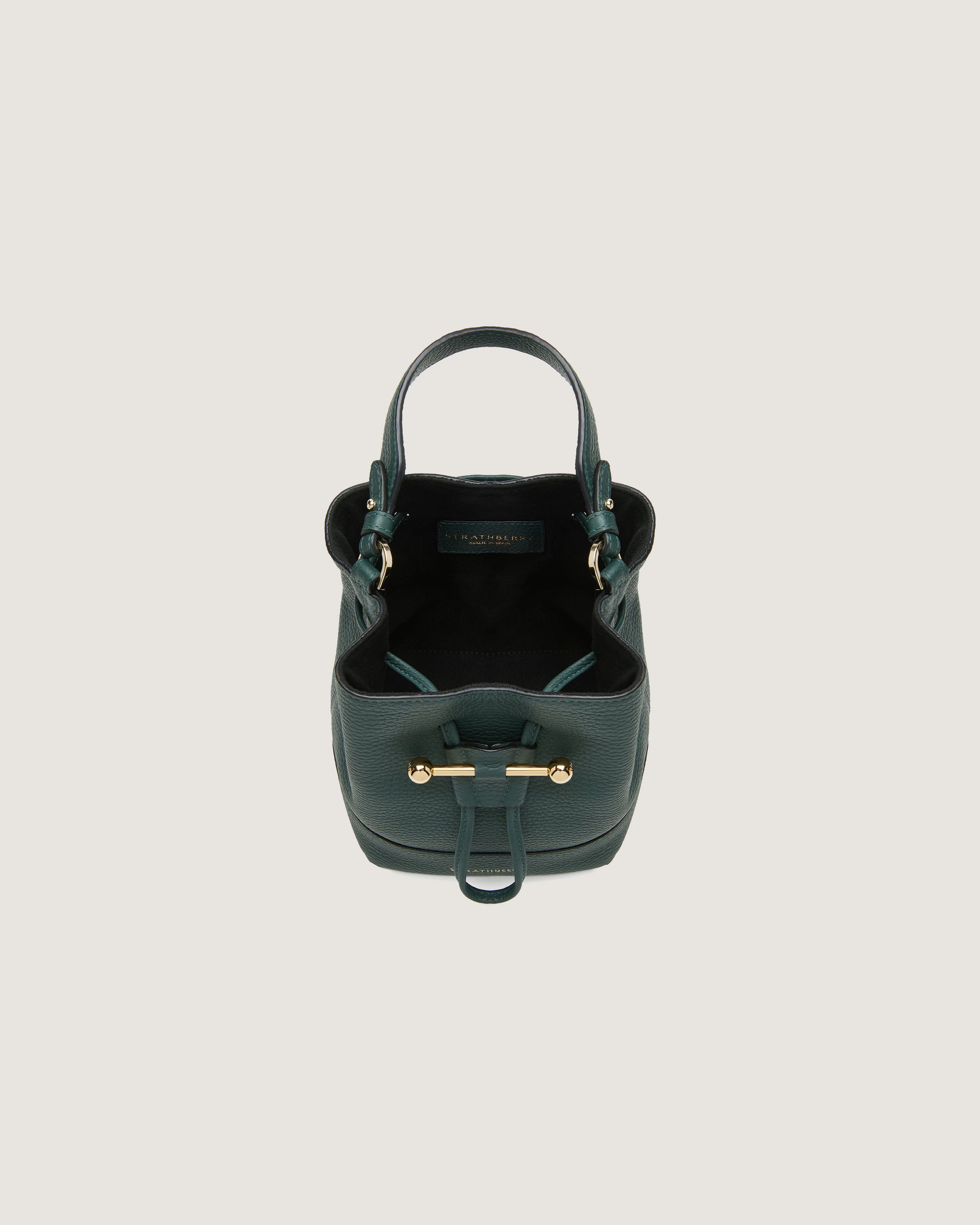 A green handbag with a gold handle