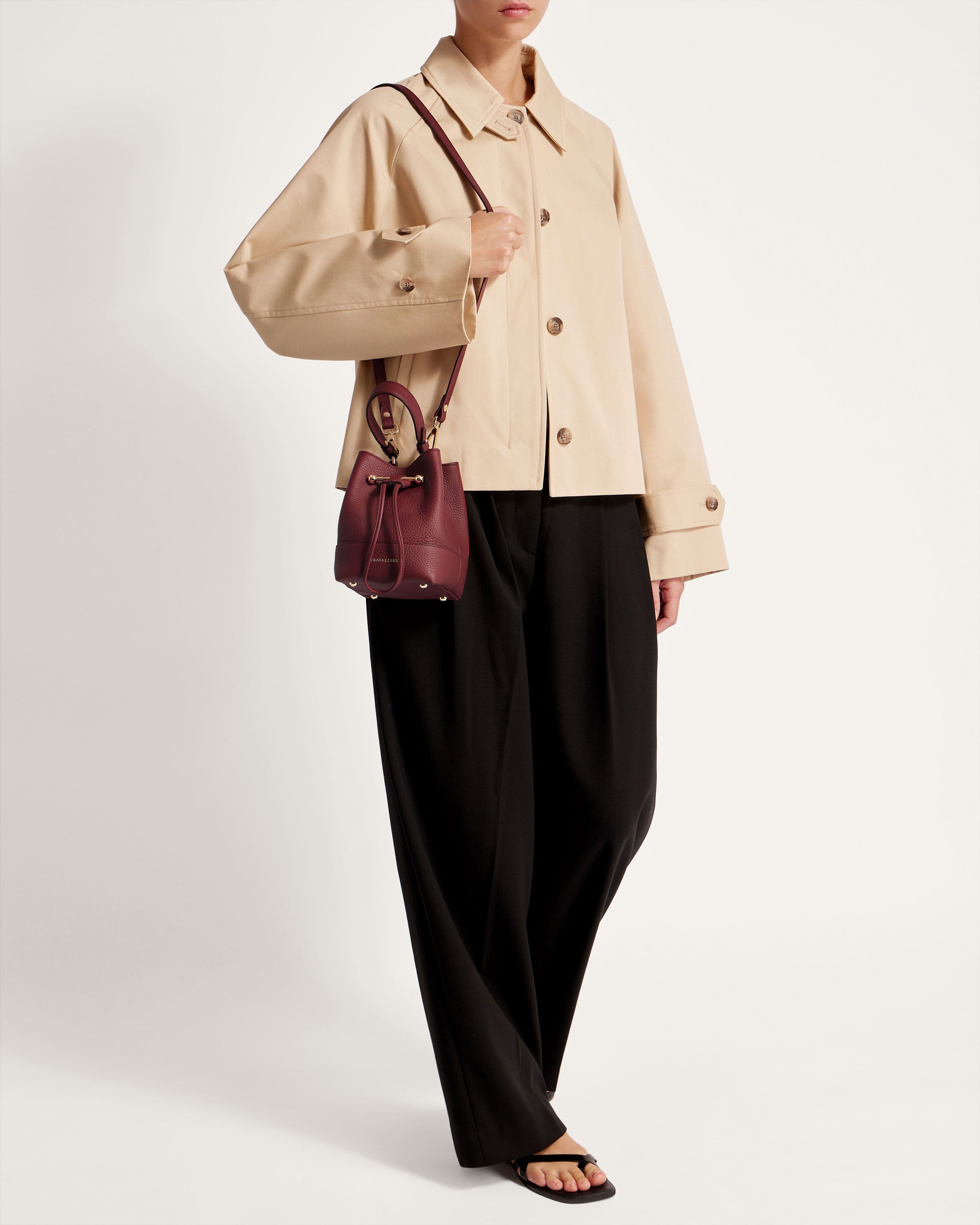 A woman in a beige jacket and black pants